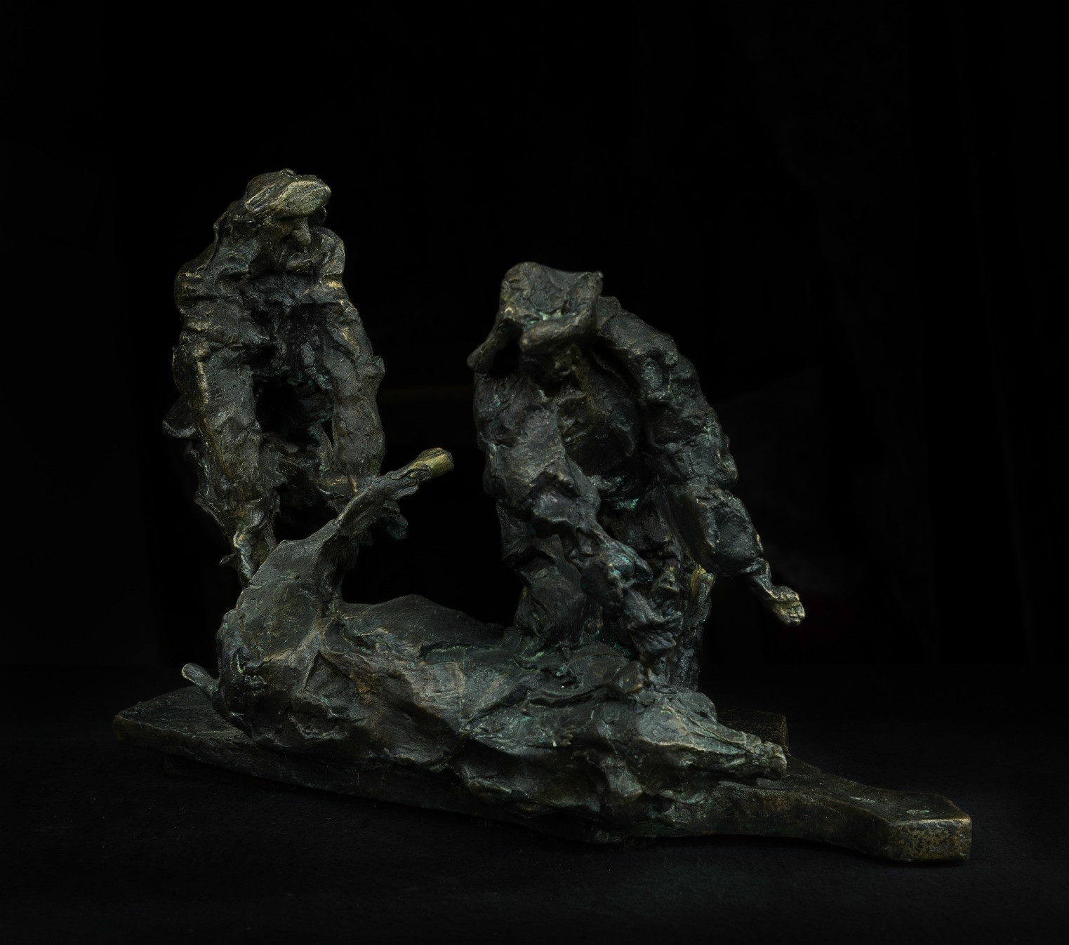 A bronze sculpture of two people sitting on a rock.