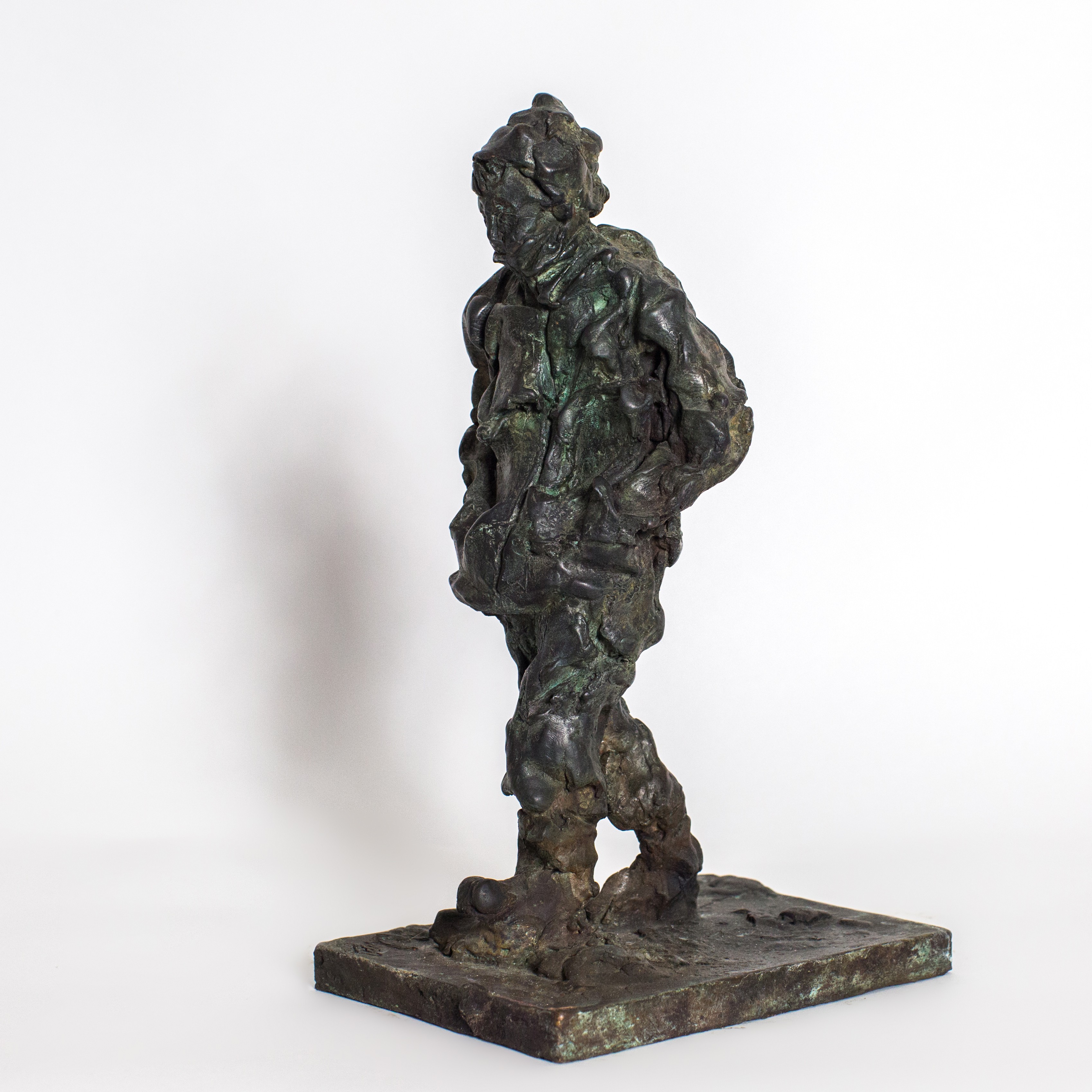 A bronze sculpture of a man standing on a rock.