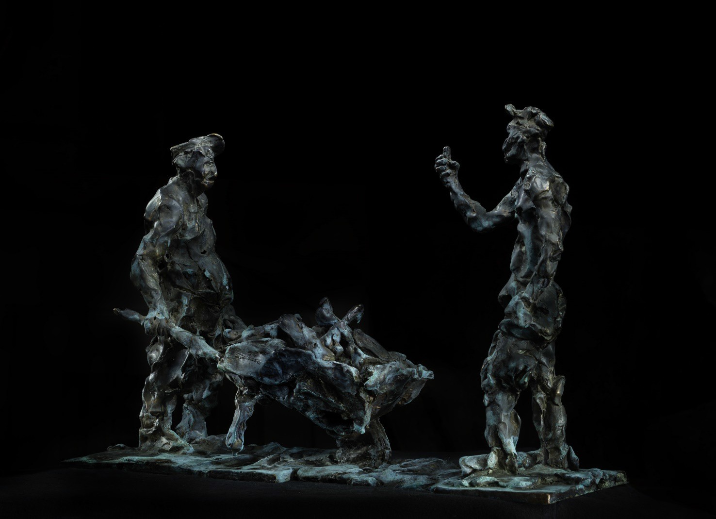 A bronze sculpture of two men and a dog on a black background.
