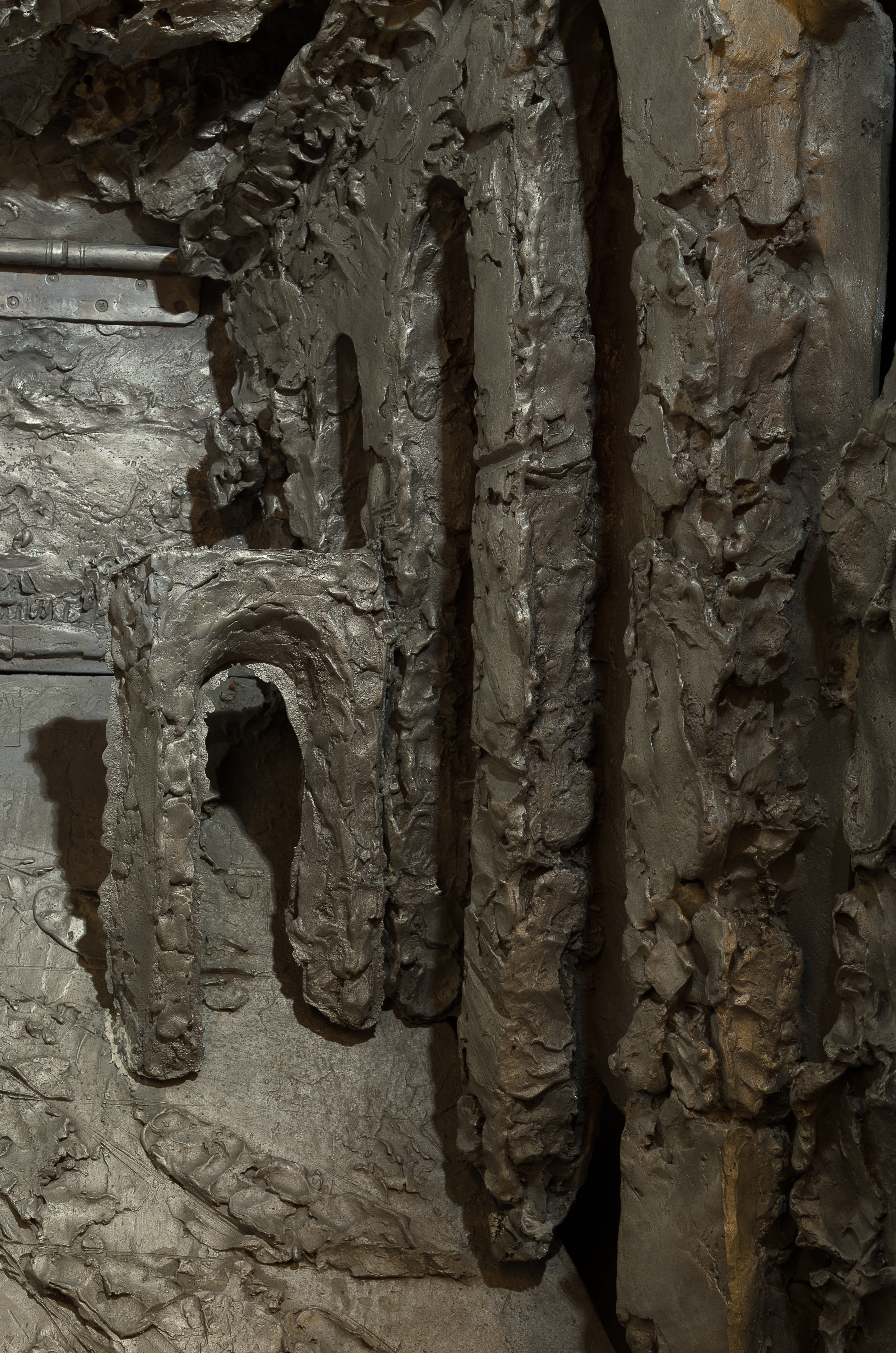 A desk with a lamp and a statue in front of a wall.