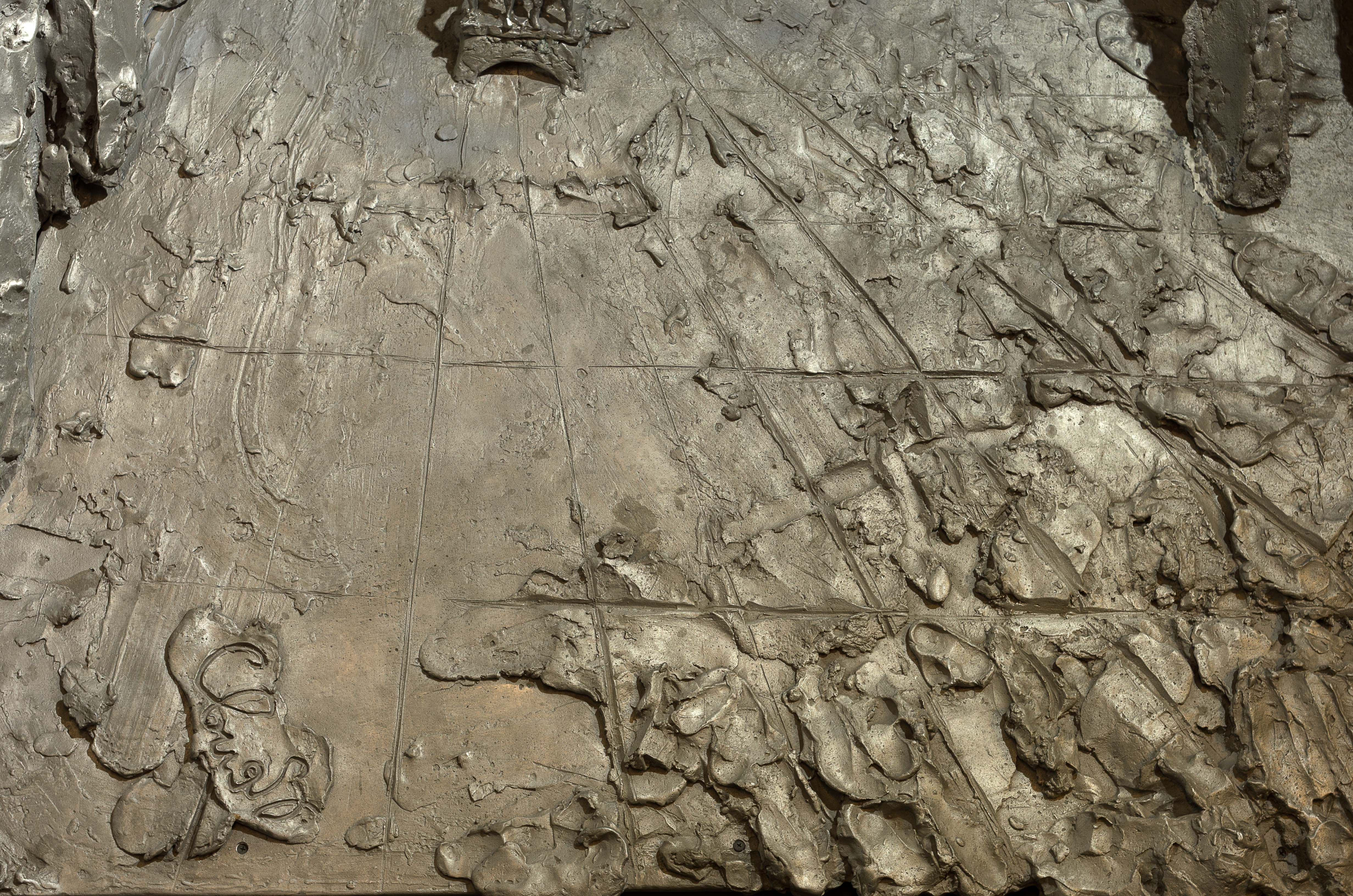 A desk with a lamp and a statue in front of a wall.