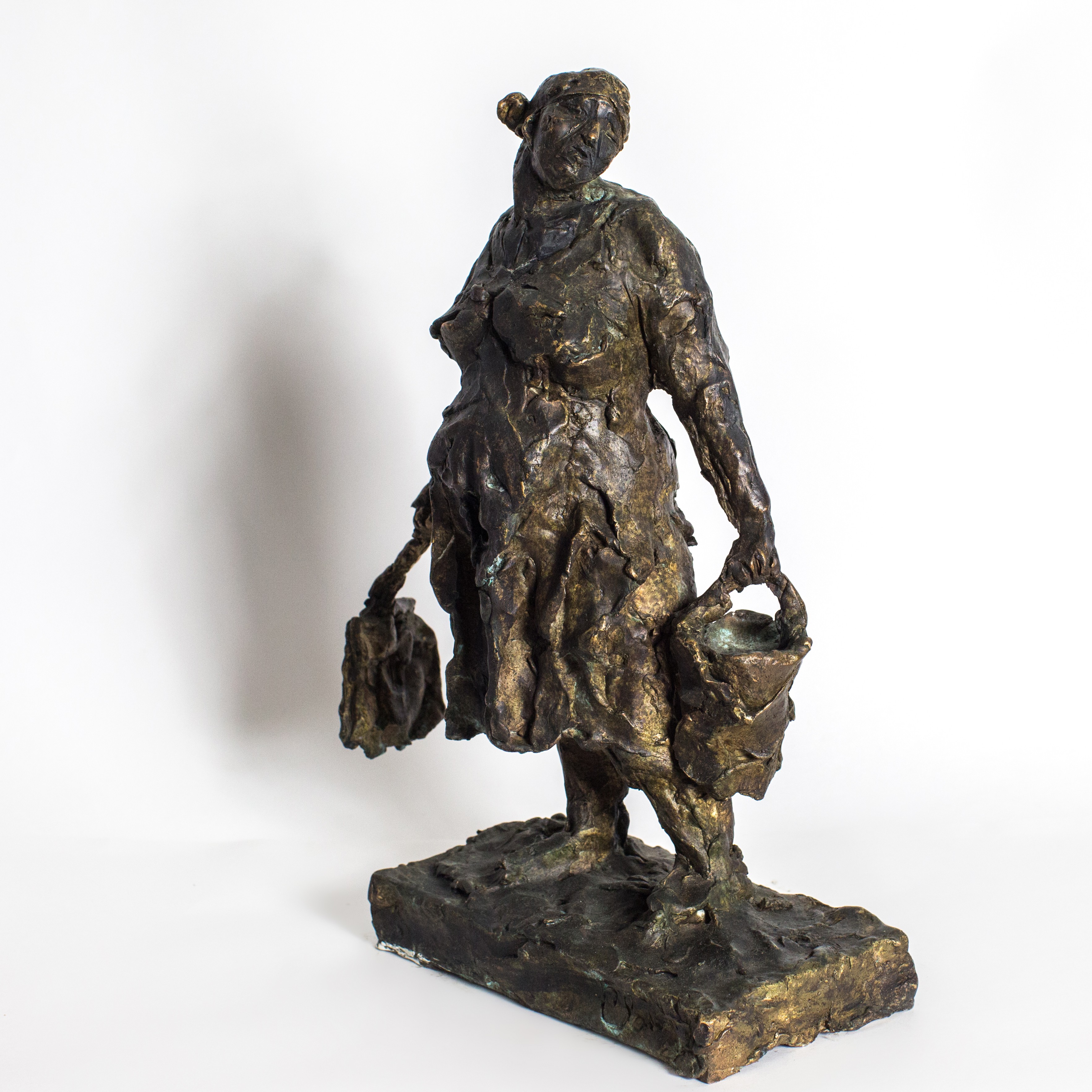 A bronze statue of a woman carrying a basket.