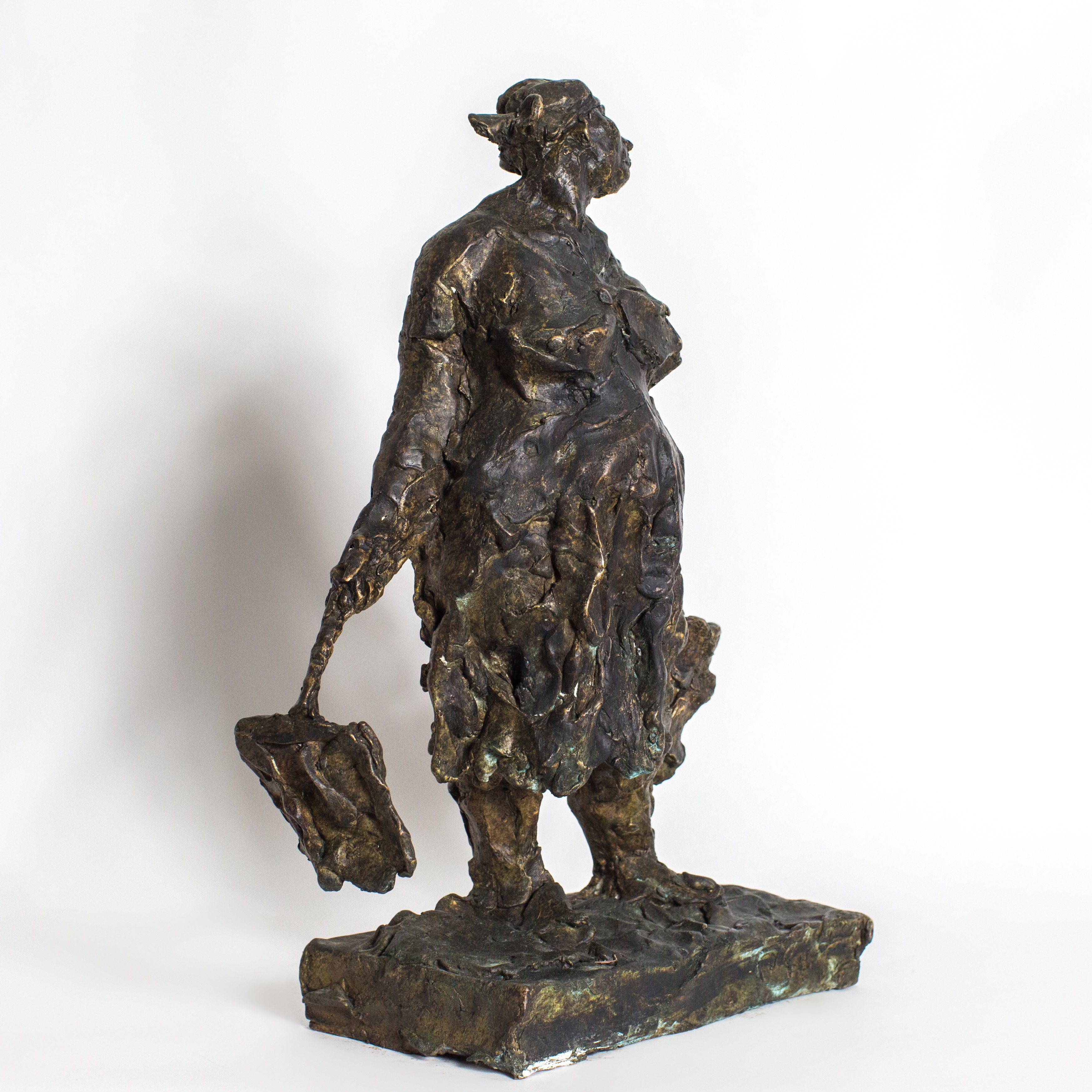 A bronze statue of a woman carrying a basket.