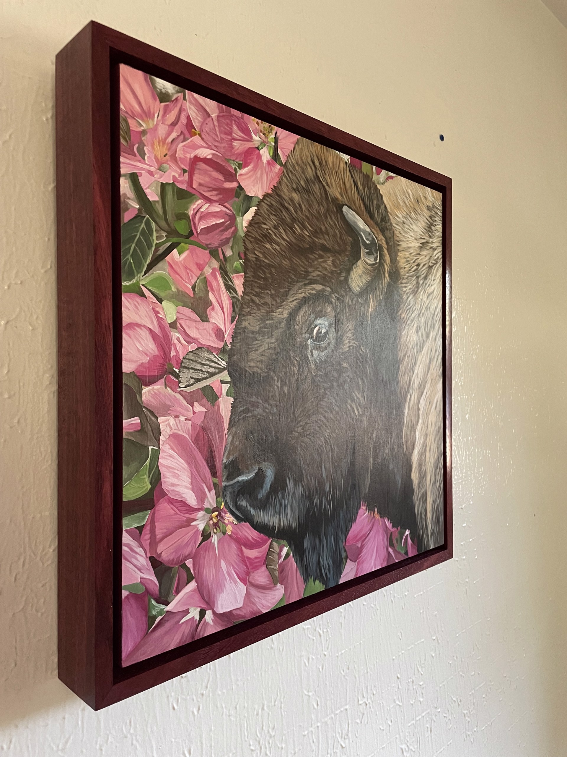 A painting of a bison in a field of pink flowers.