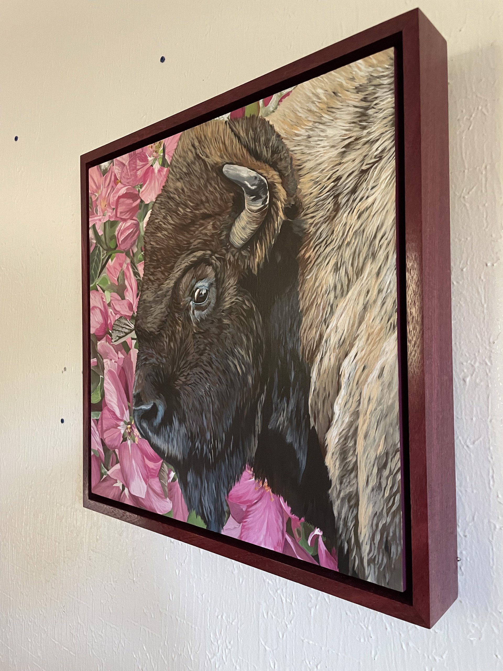 A painting of a bison in a field of pink flowers.