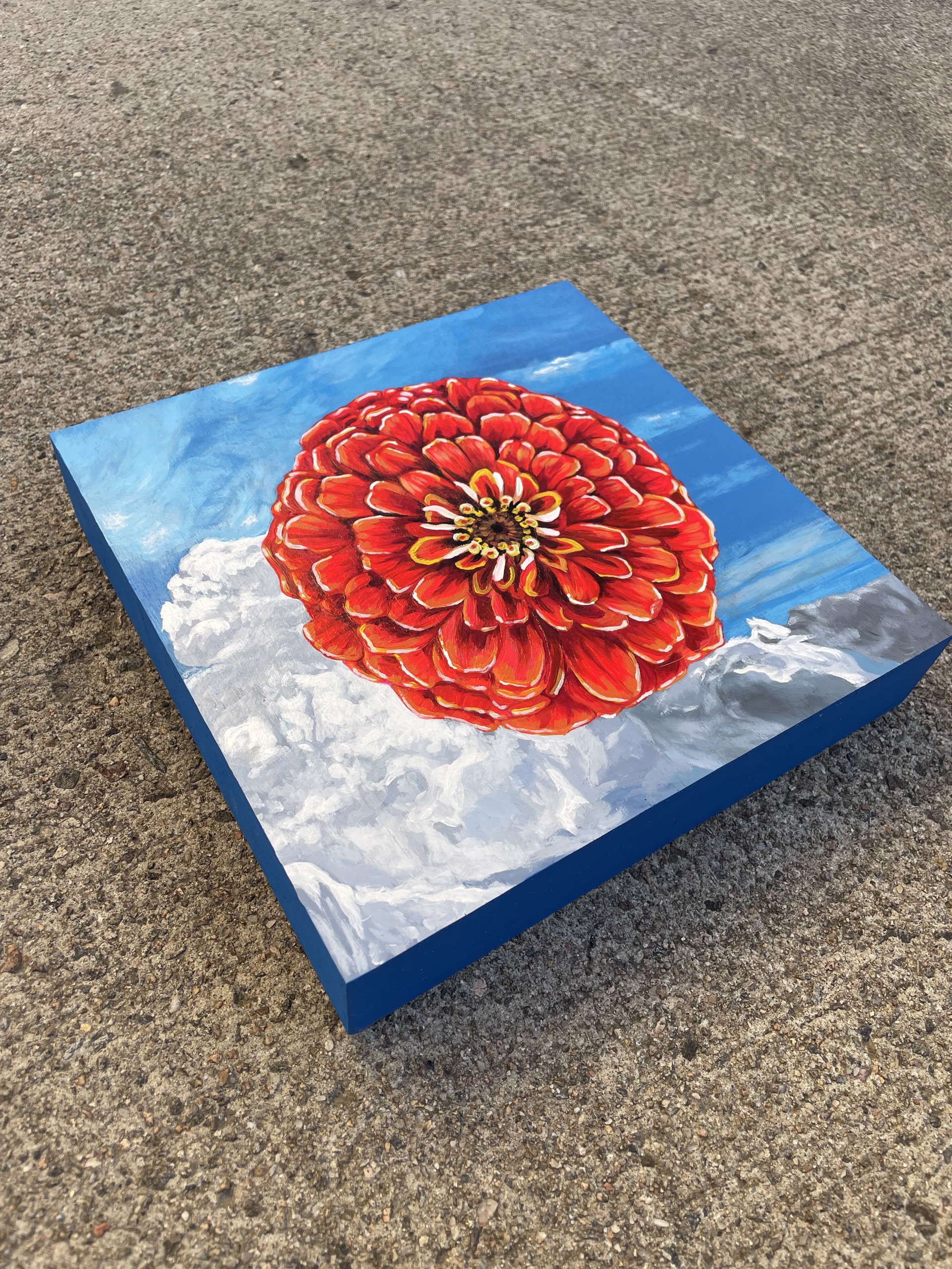 A painting of a red flower on a blue background.
