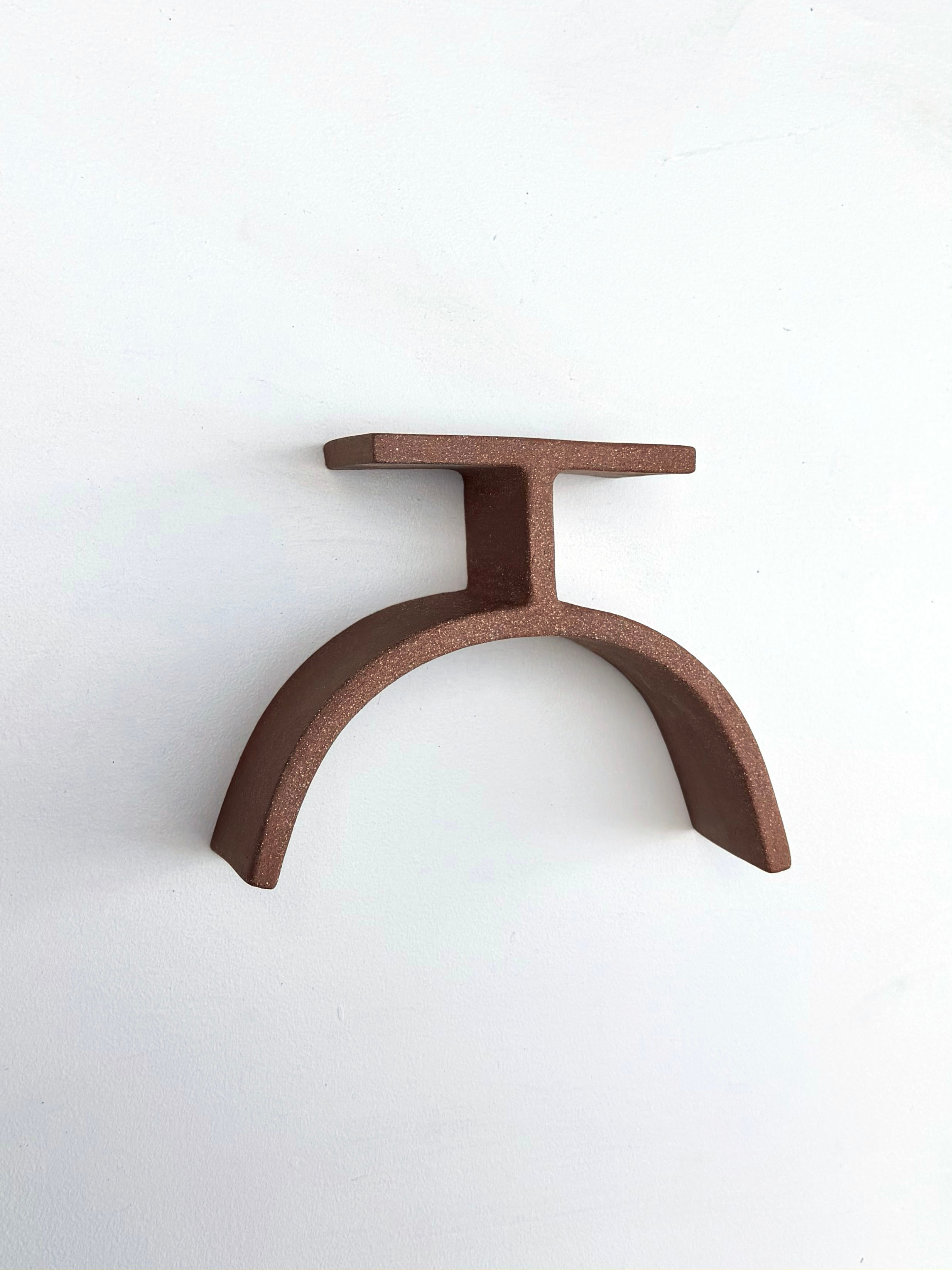 A brown metal object on a white surface.