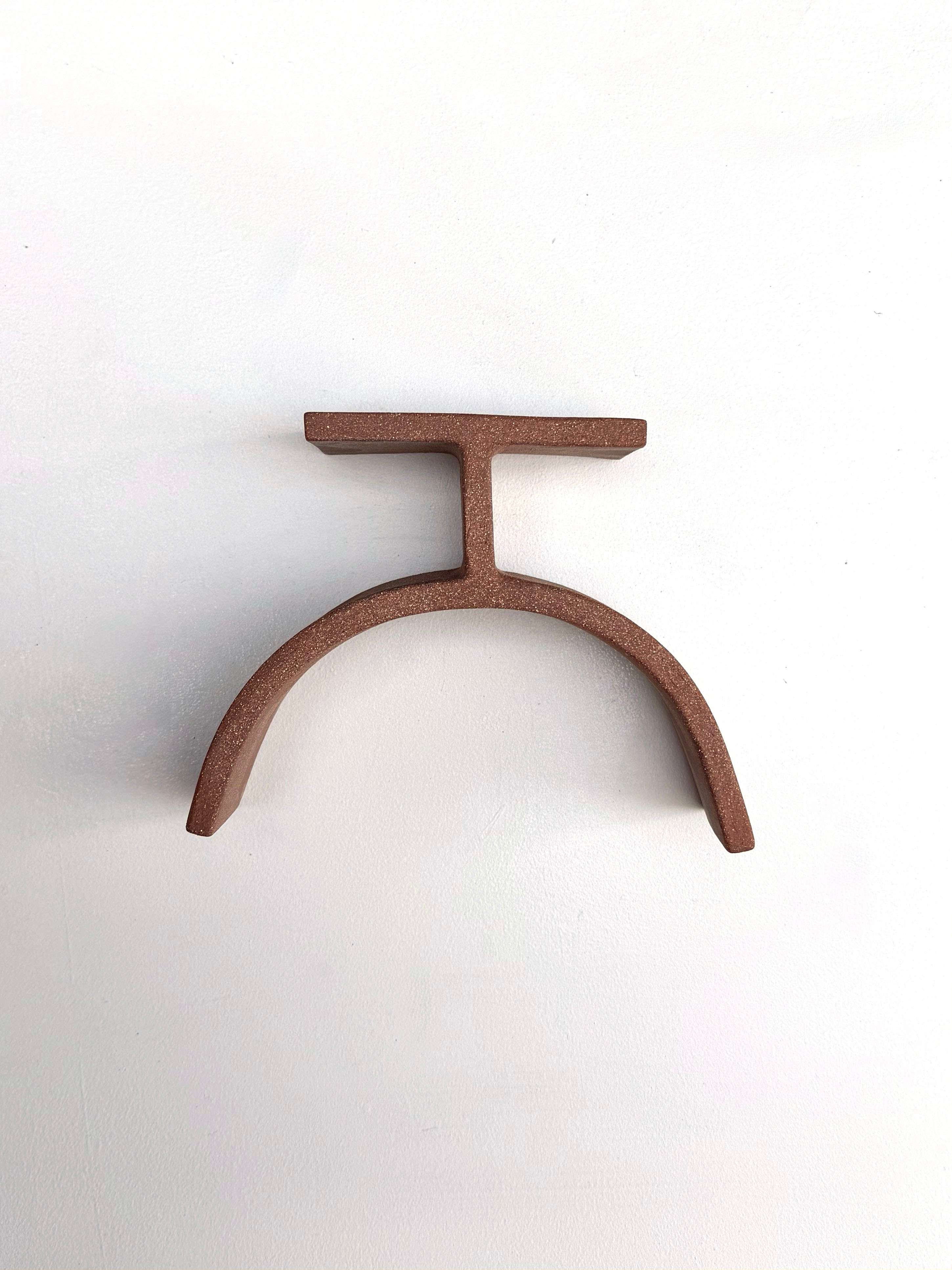 A brown metal object on a white surface.