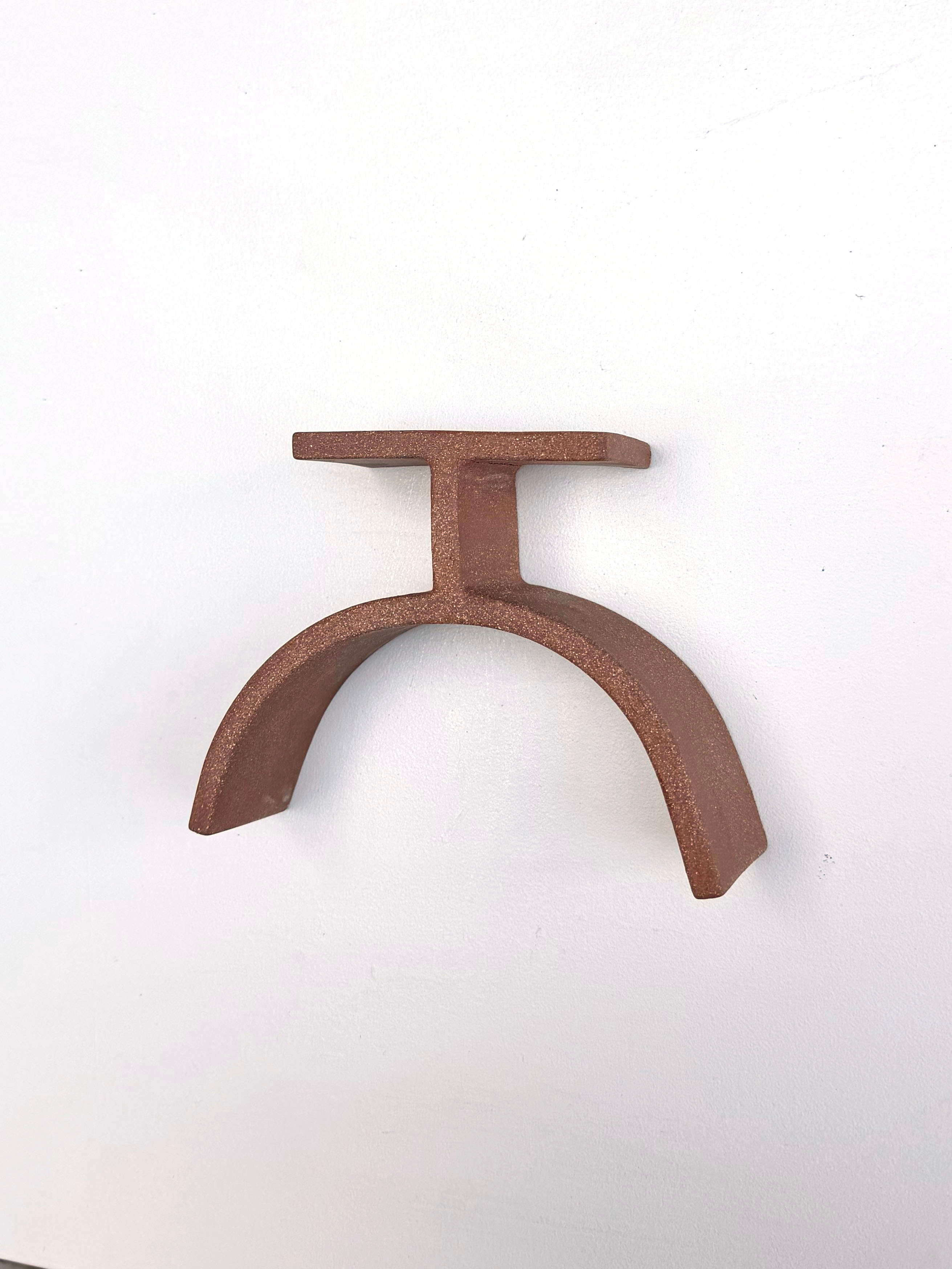 A brown metal object on a white surface.