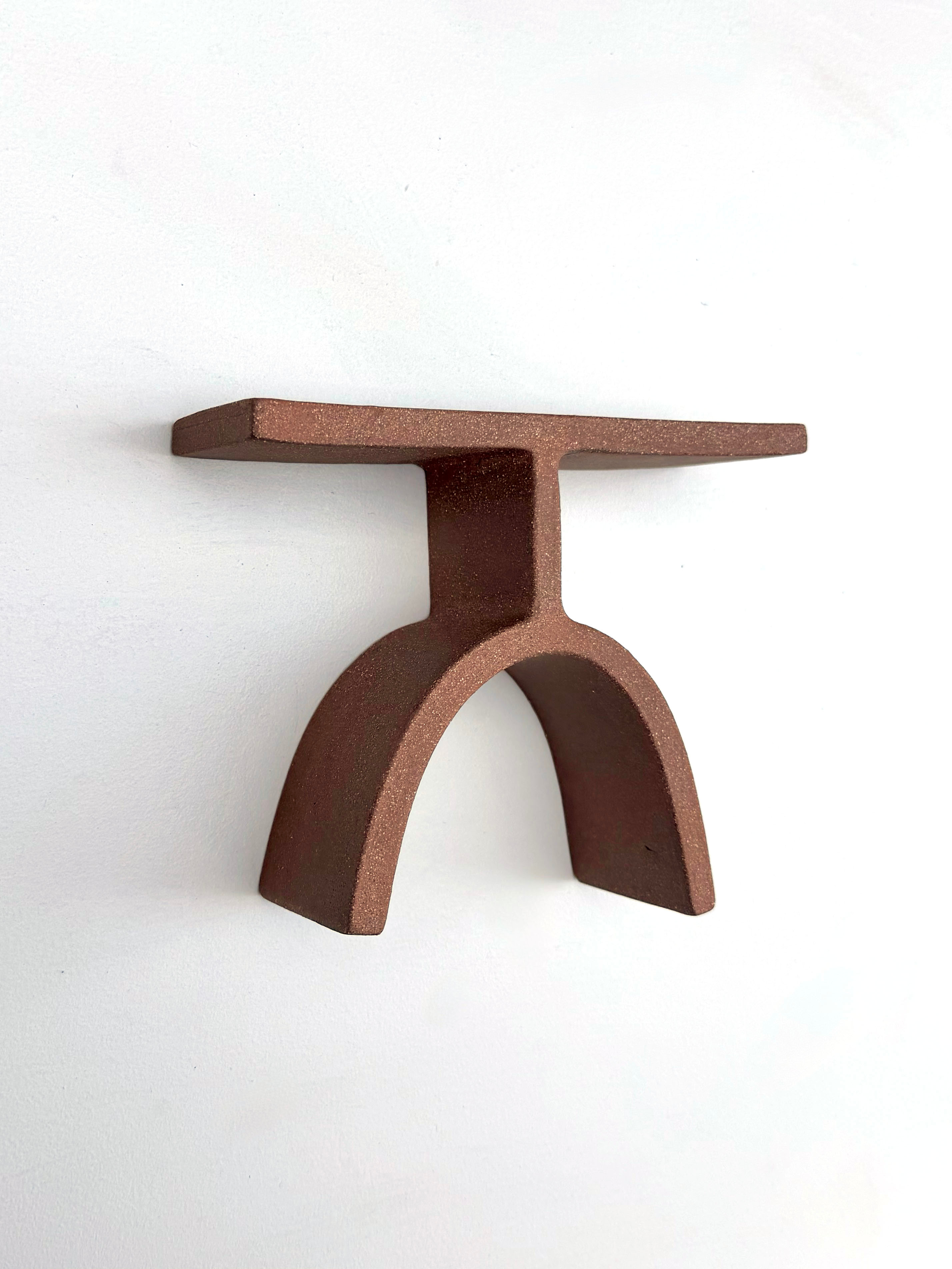 A brown metal object on a white surface.