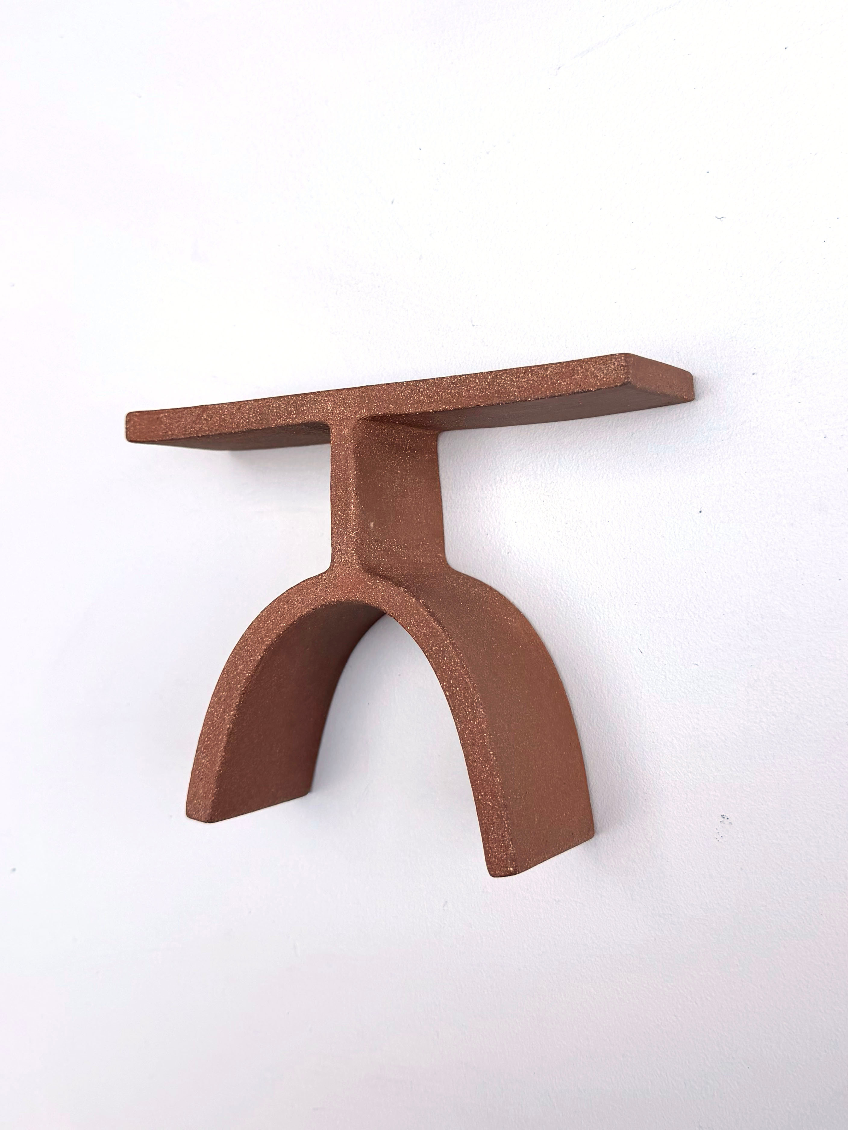 A brown metal object on a white surface.