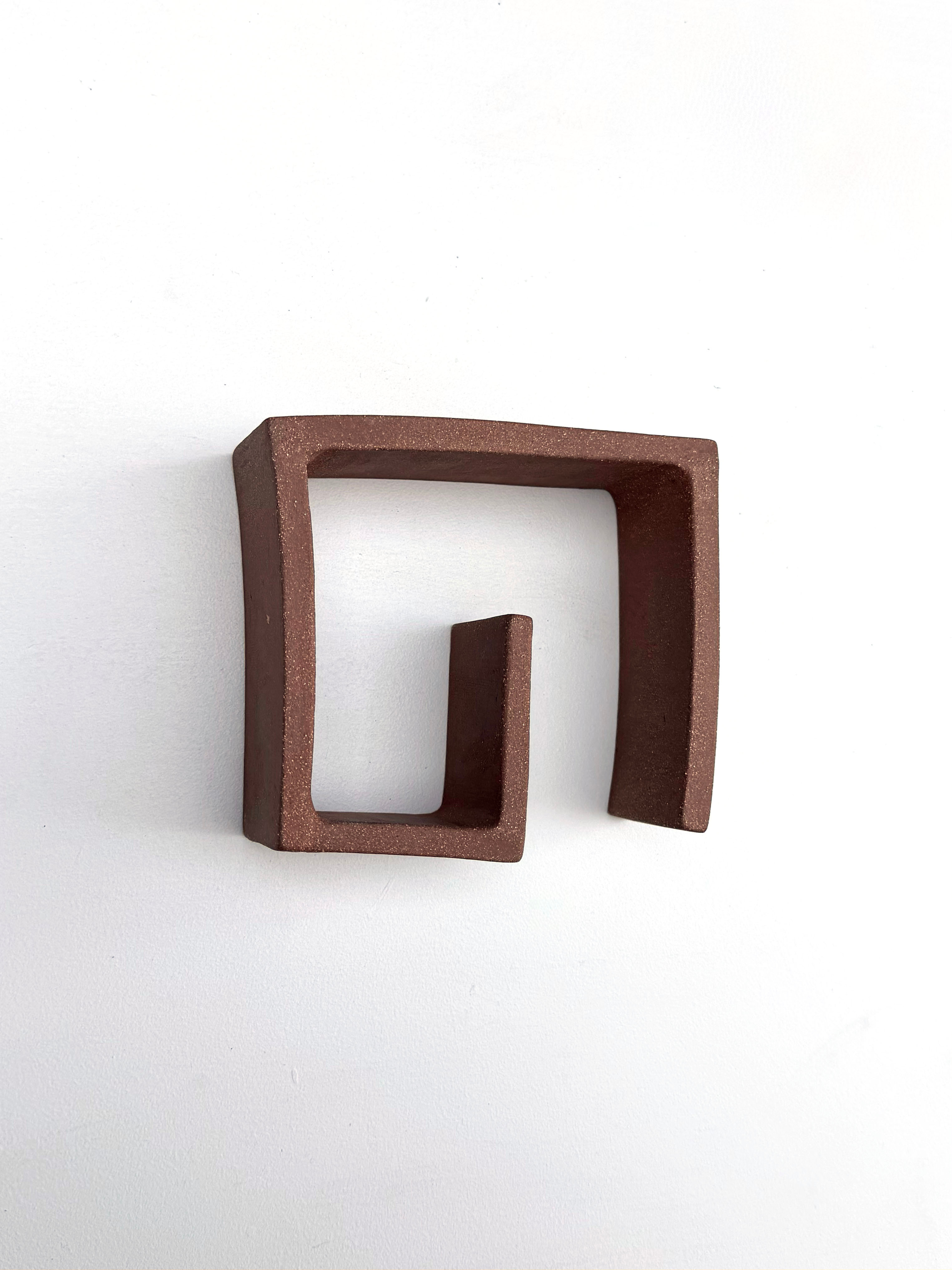 A brown square shaped object on a white surface.