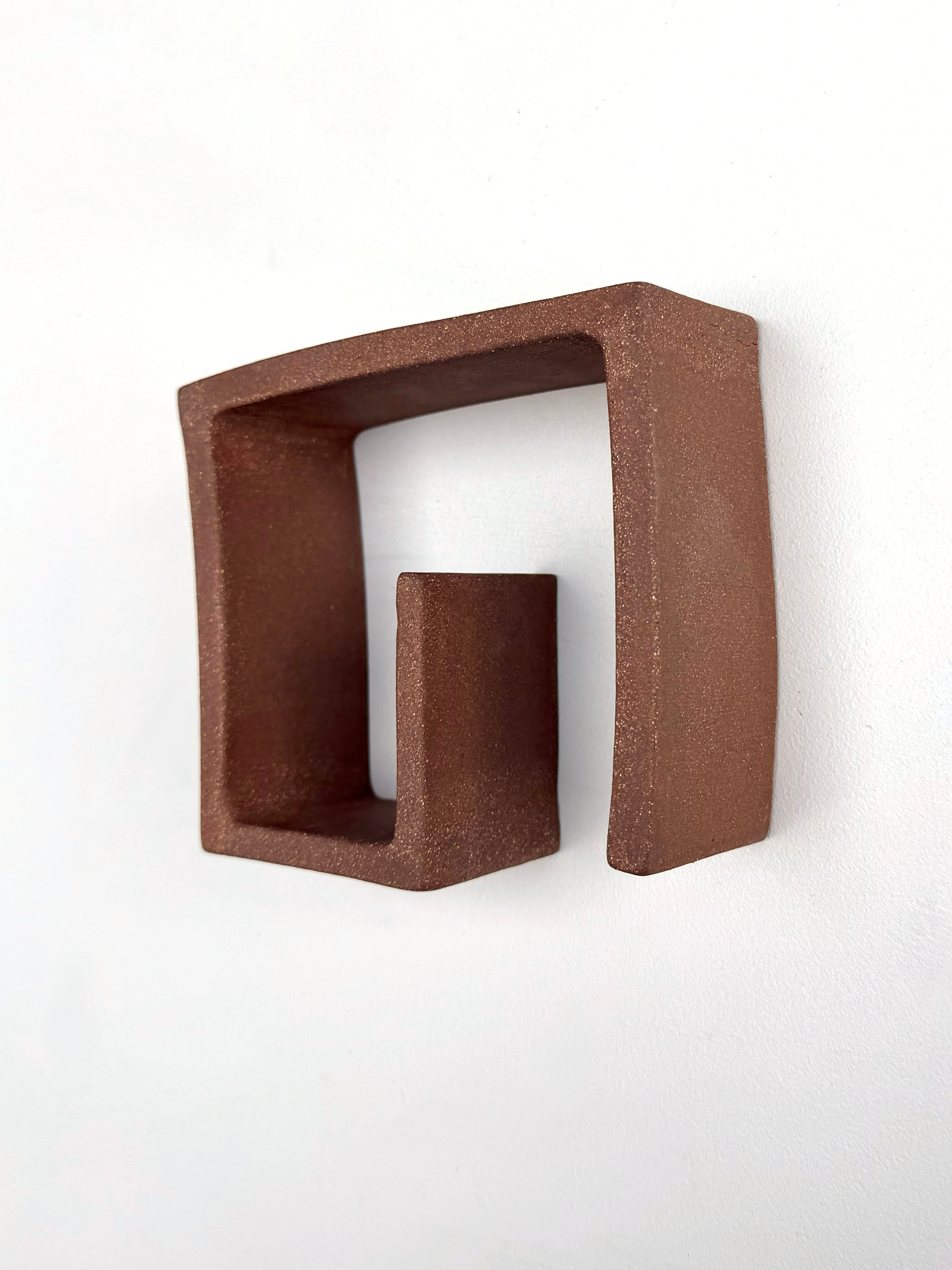 A brown square shaped object on a white surface.