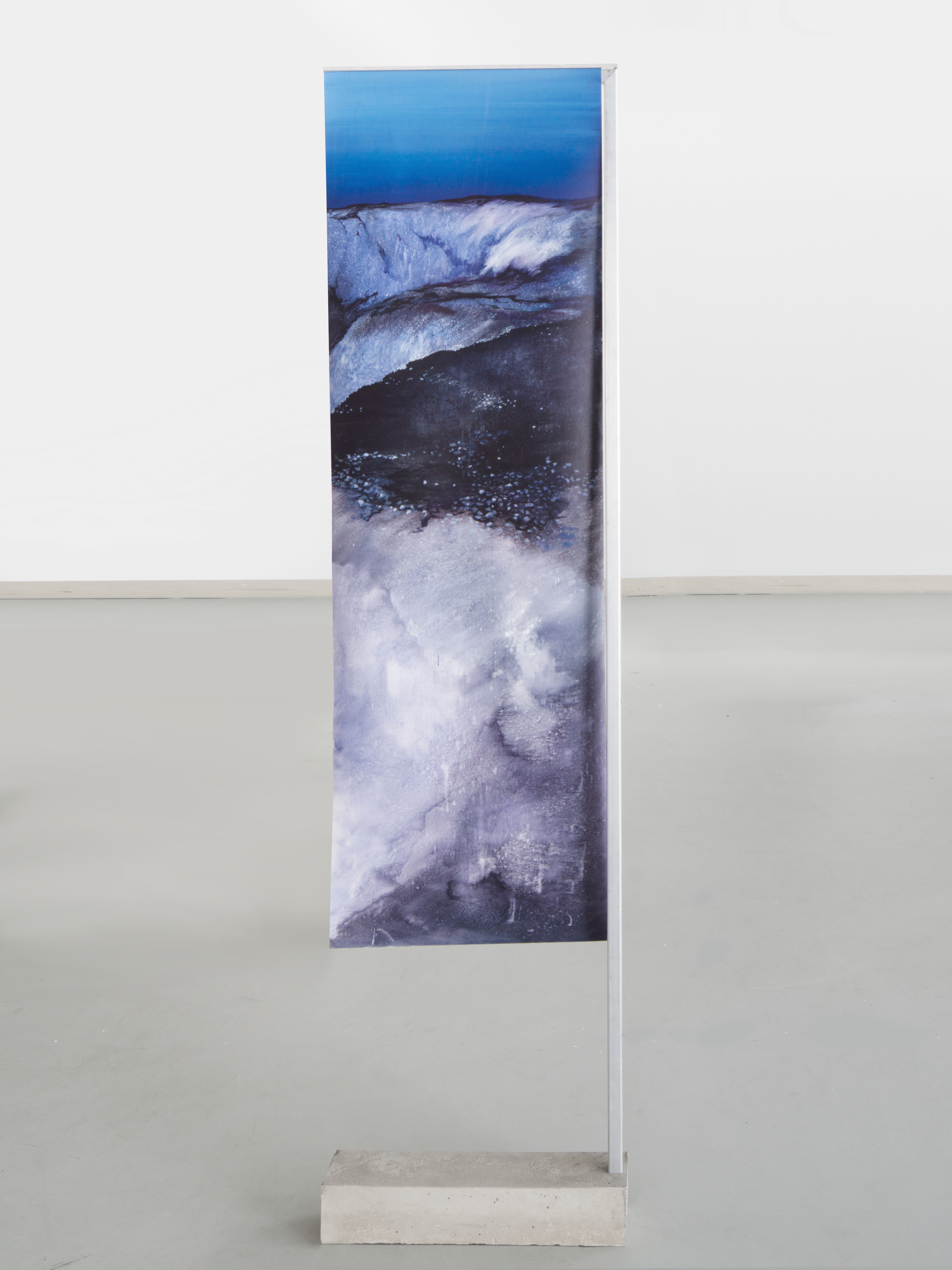 A painting on a stand in a room with a white wall.
