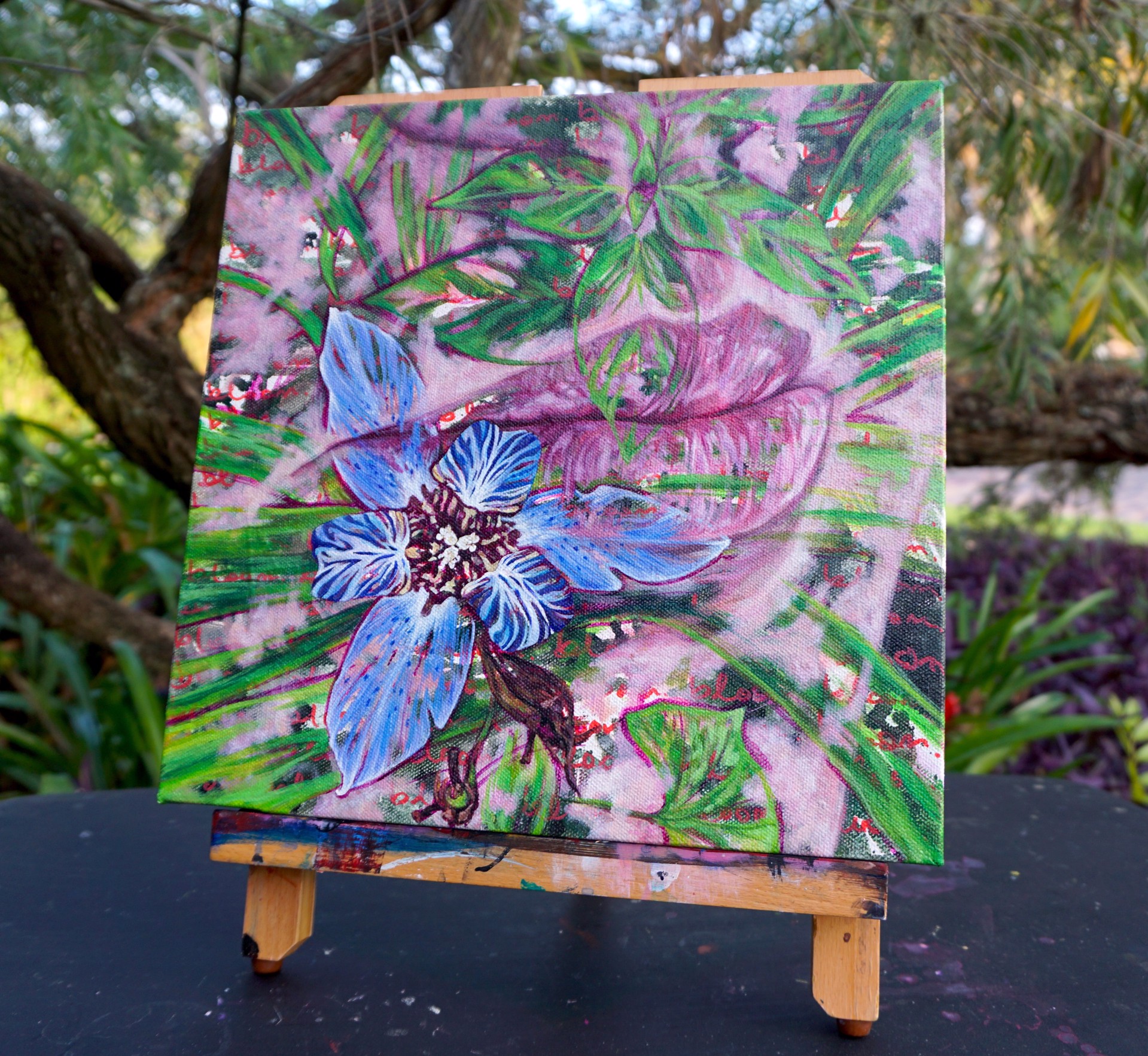 A painting of a blue flower on a pink background.