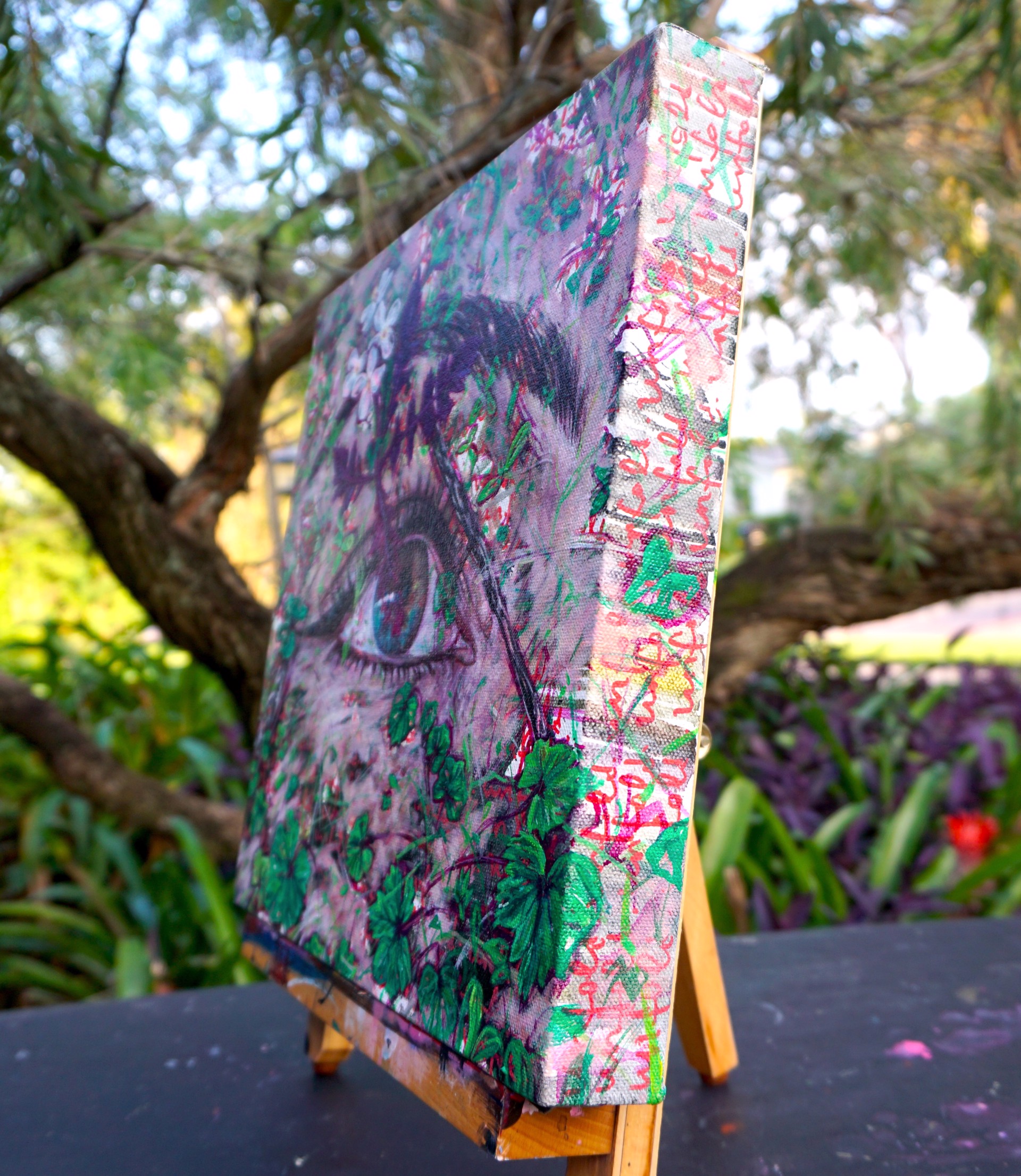A painting of a woman's eye surrounded by flowers.
