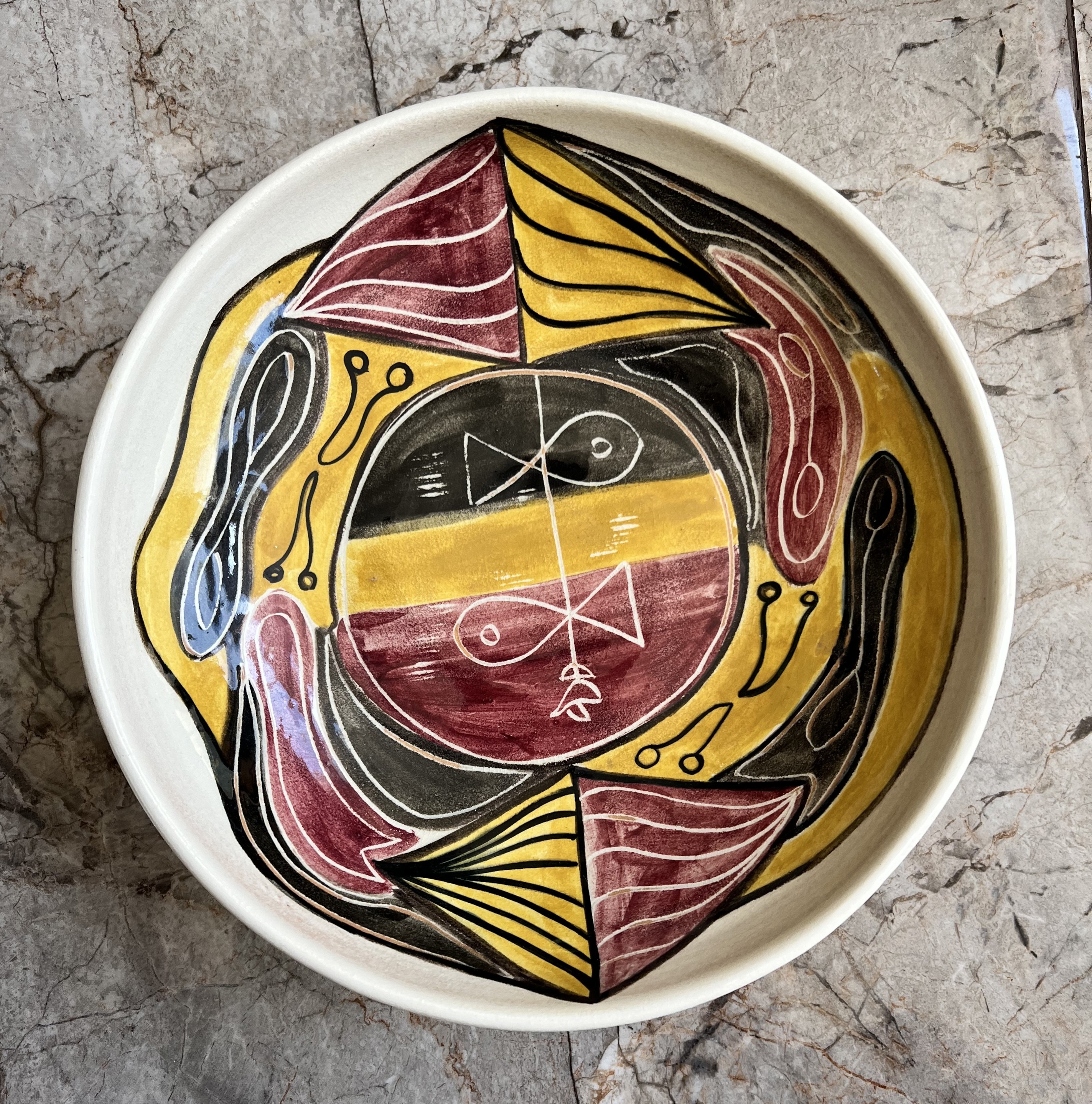 A decorative bowl on a marble surface. 