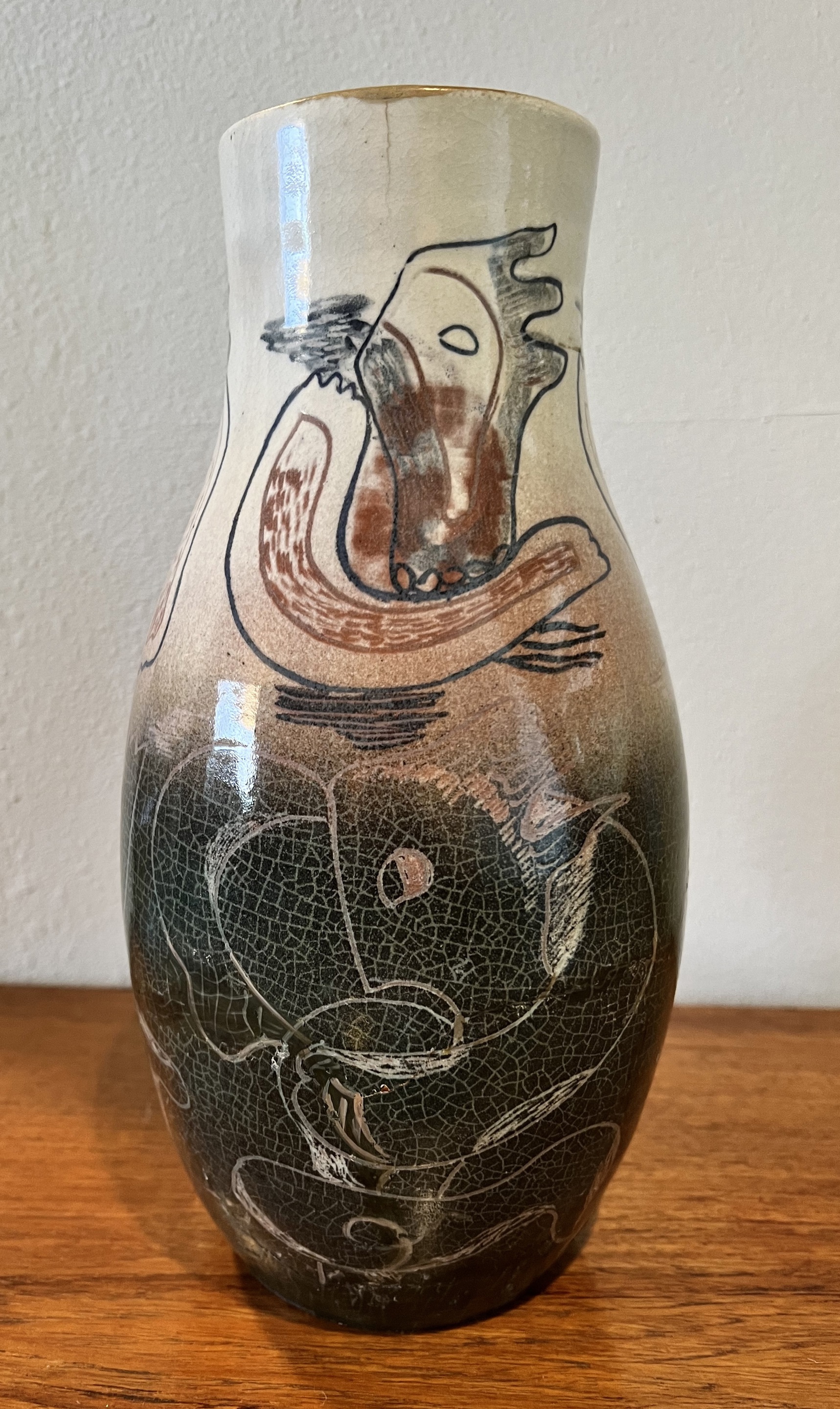 A brown vase sitting on top of a wooden table.