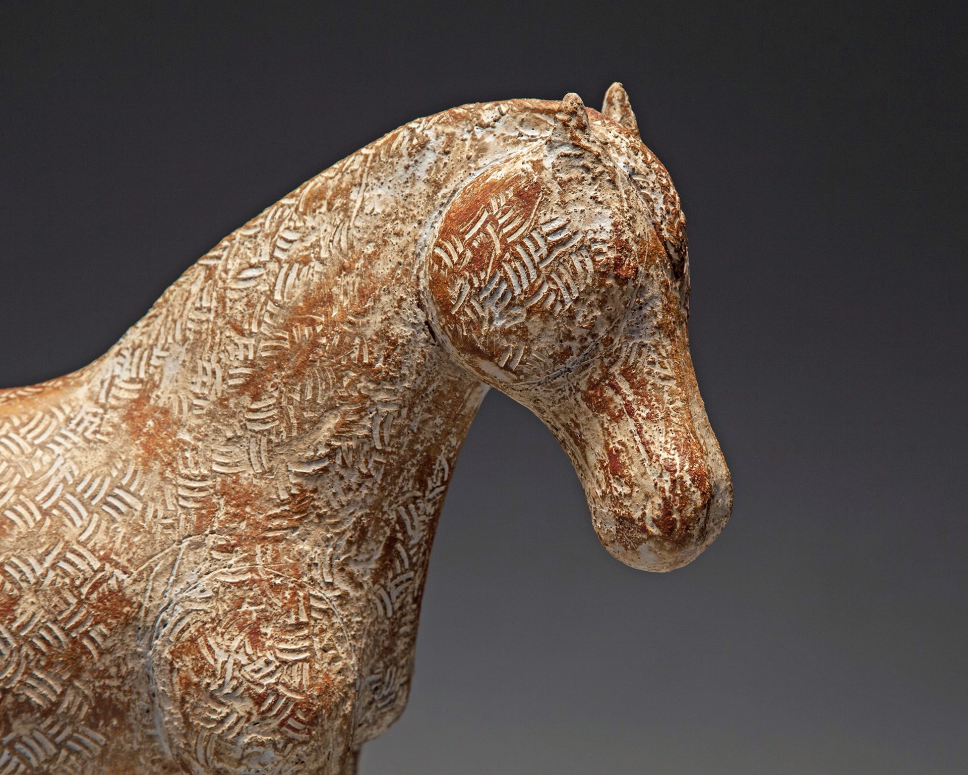 A wooden horse with wheels on a gray background.