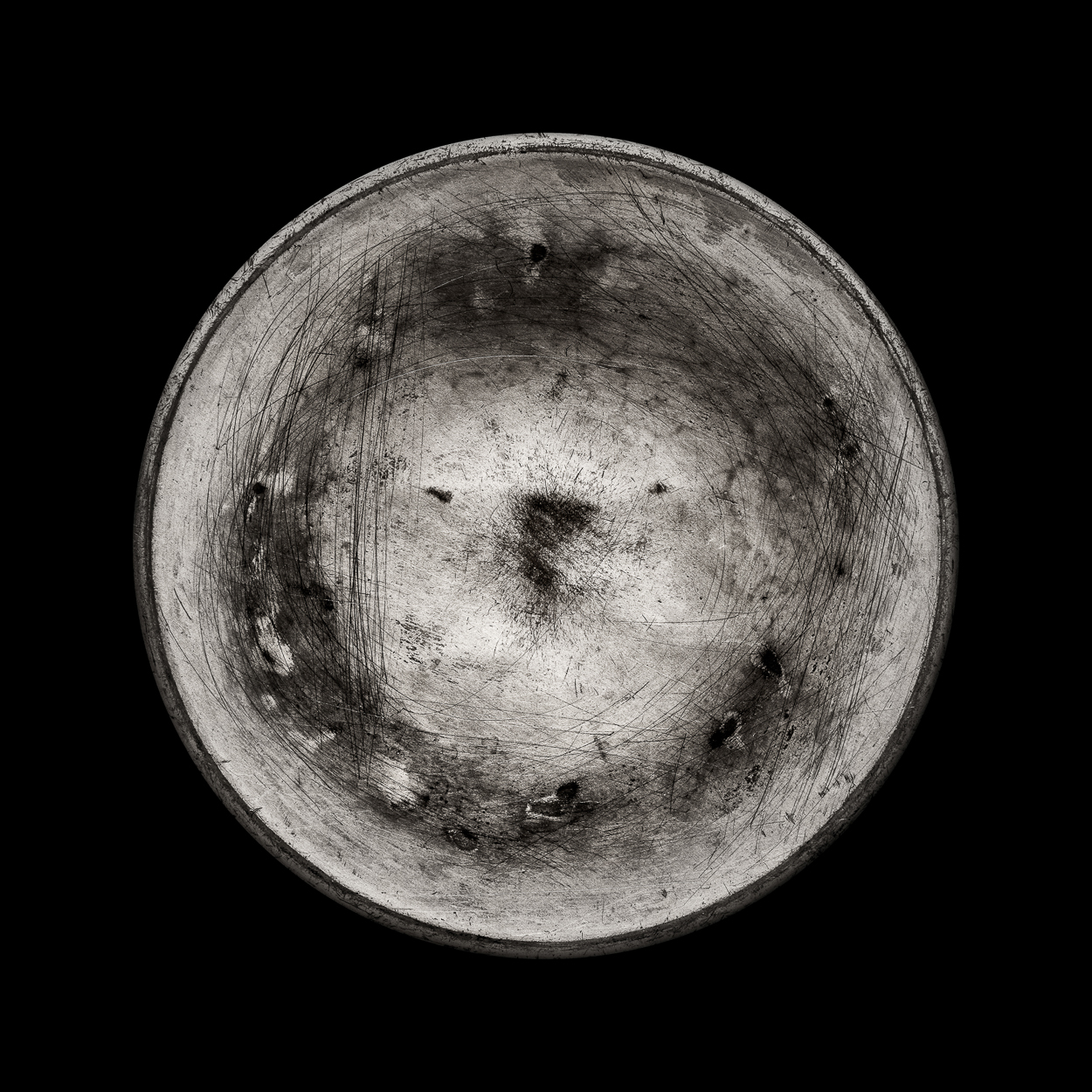 A black and white photo of a bowl on a black background.
