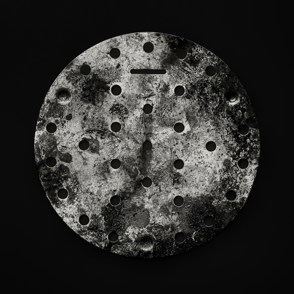 A black and white photo of the moon with holes in it.