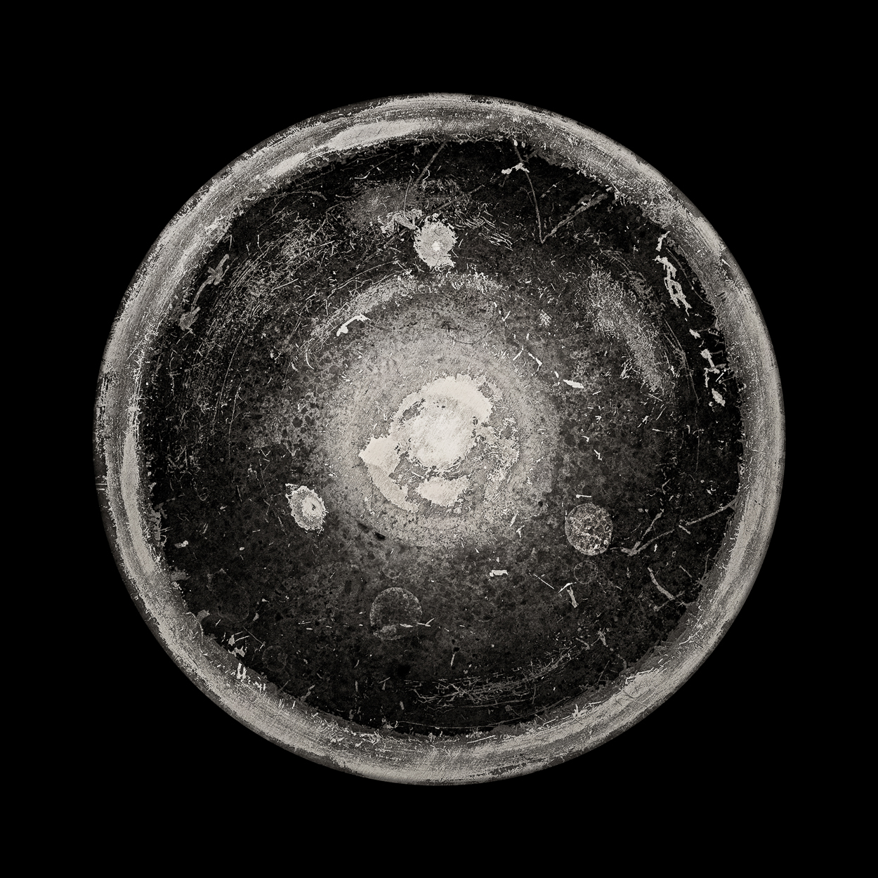 A black and white photo of a bowl on a black background.