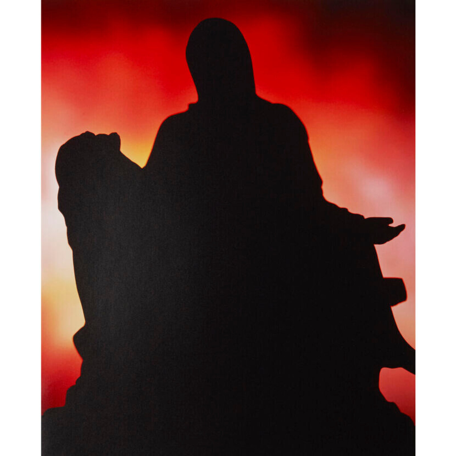A framed print featuring a black silhouette of a figure against a fiery red and orange background.