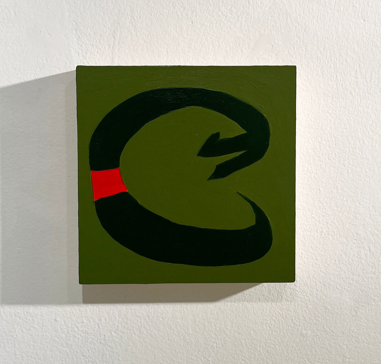 A bold, abstract composition featuring a thick black loop with a red square against an olive green background.