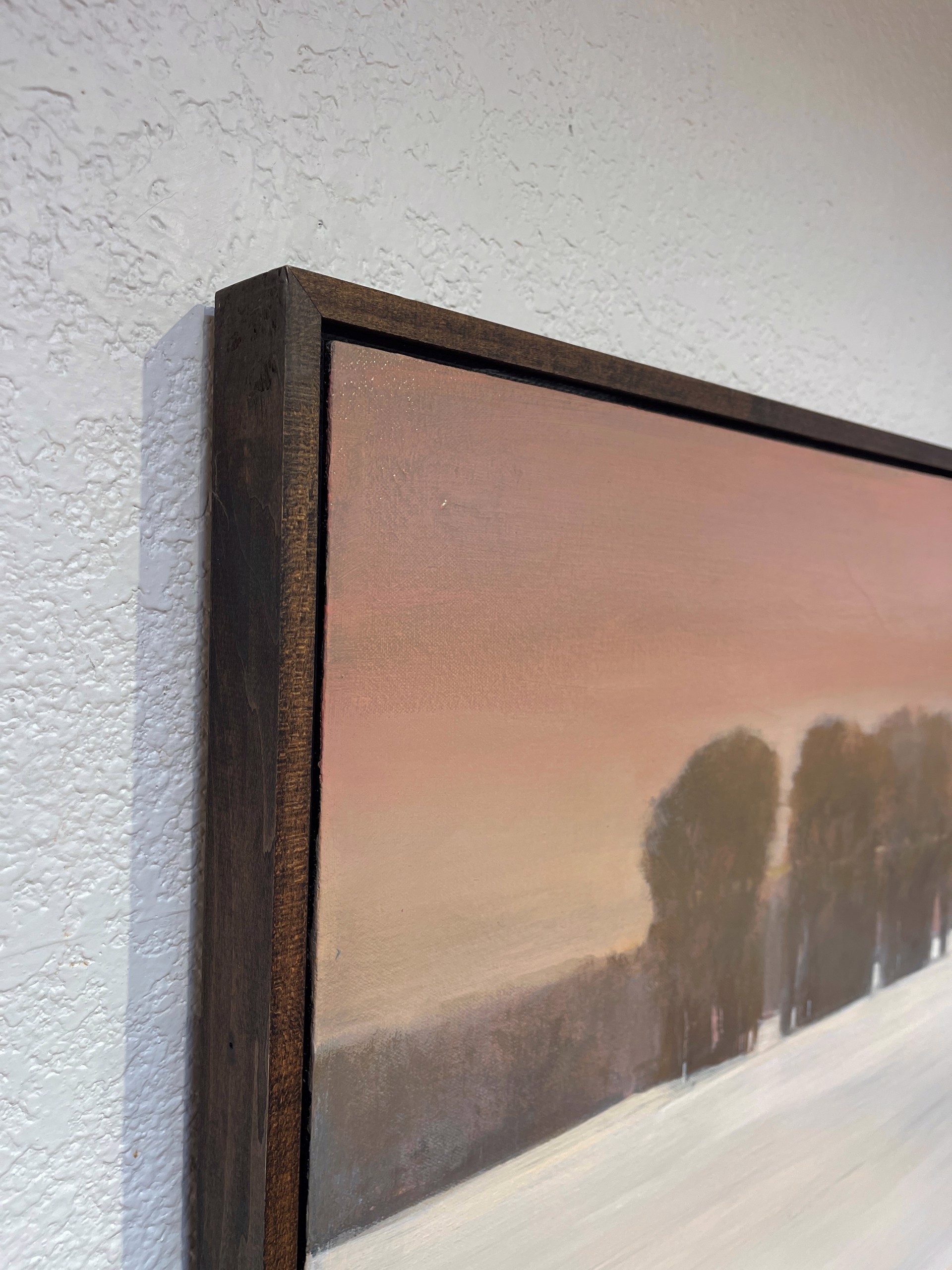 A painting of a snow covered field with trees in the distance.
