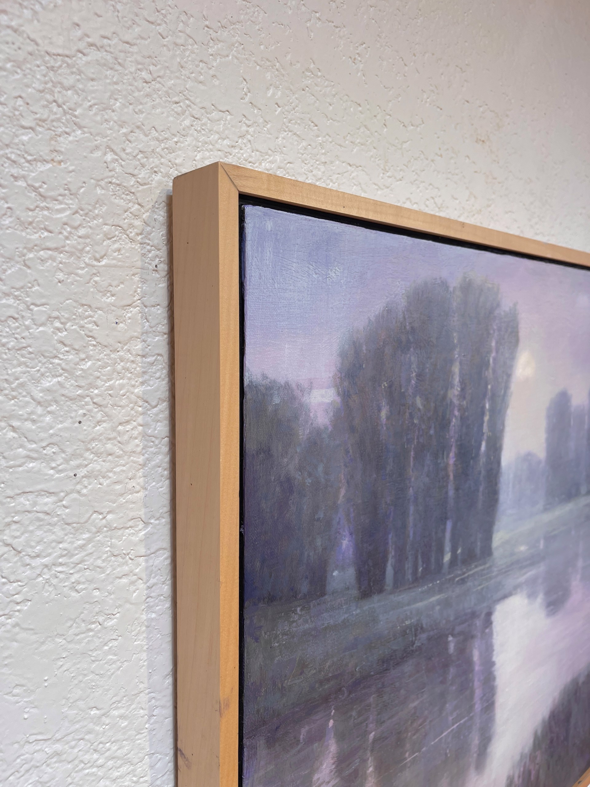 A moody landscape painting of a misty riverbank at twilight.