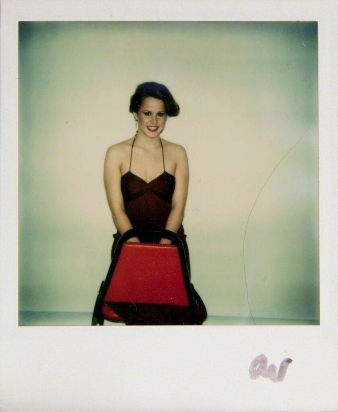 A woman in a red dress holding a red purse.