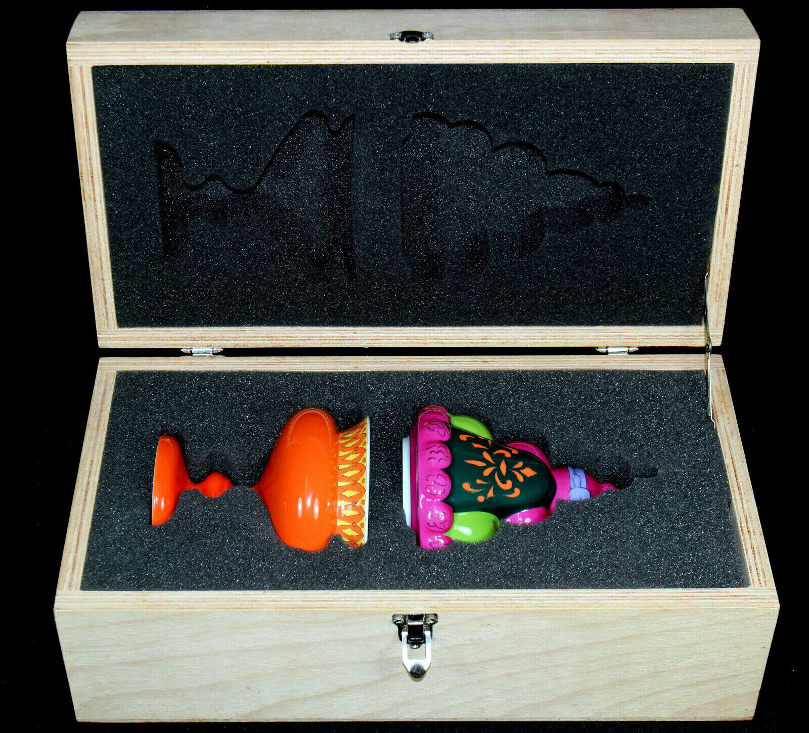 An orange vase with a pink hat on top of it.