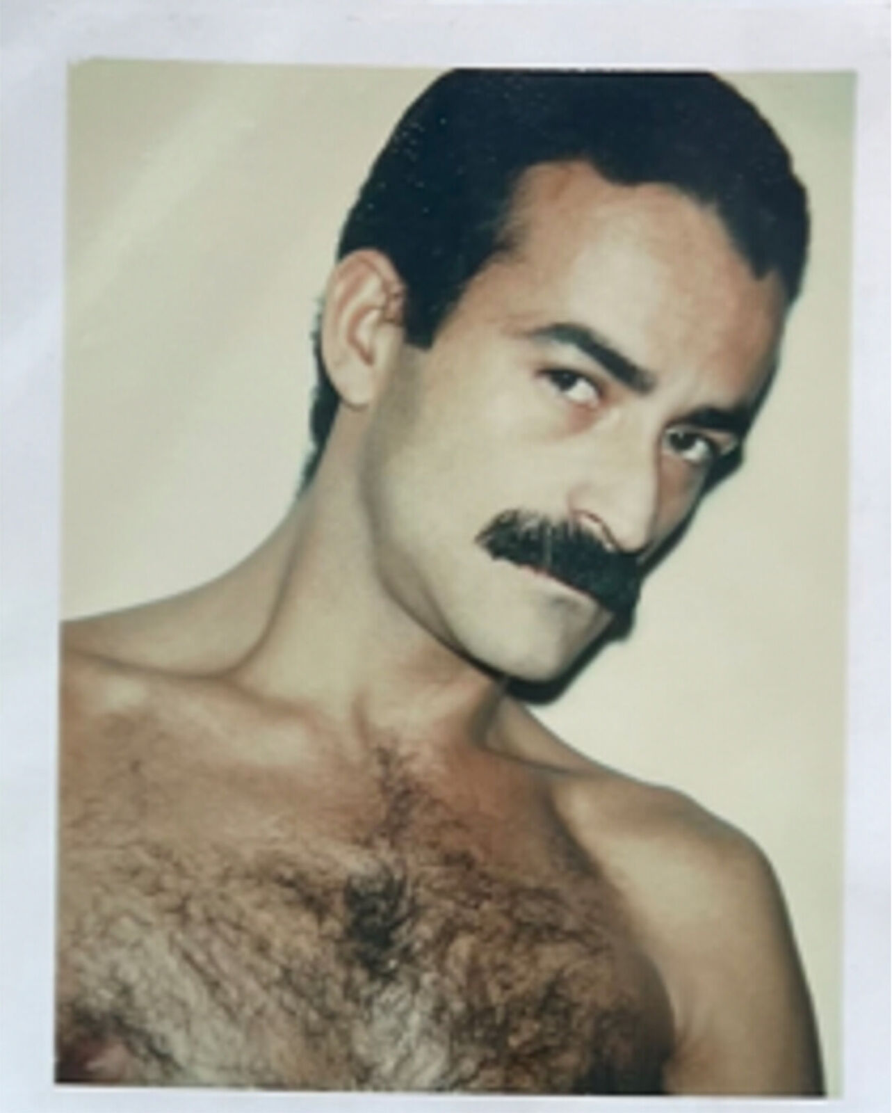 A man with a moustache on his face and no shirt.