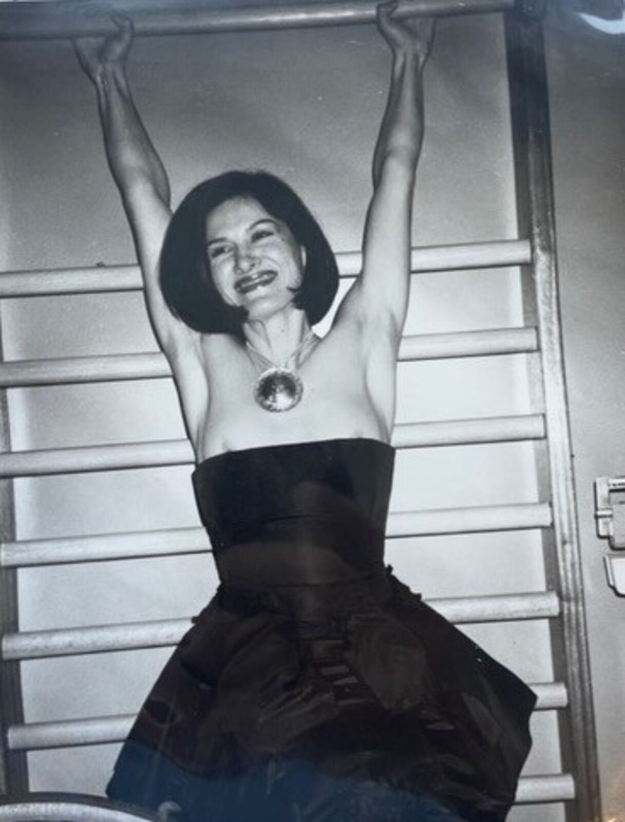 A black and white photo of a woman in a black dress.