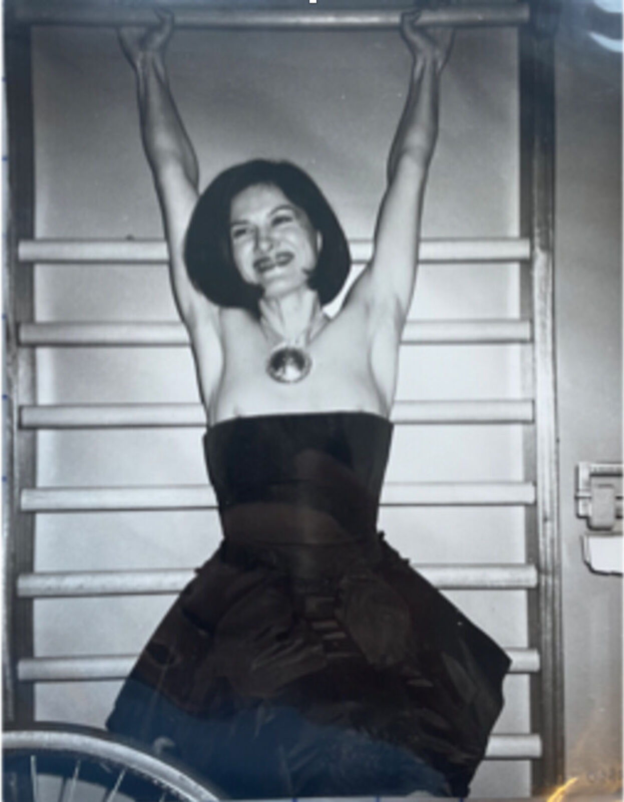 A black and white photo of a woman in a black dress.