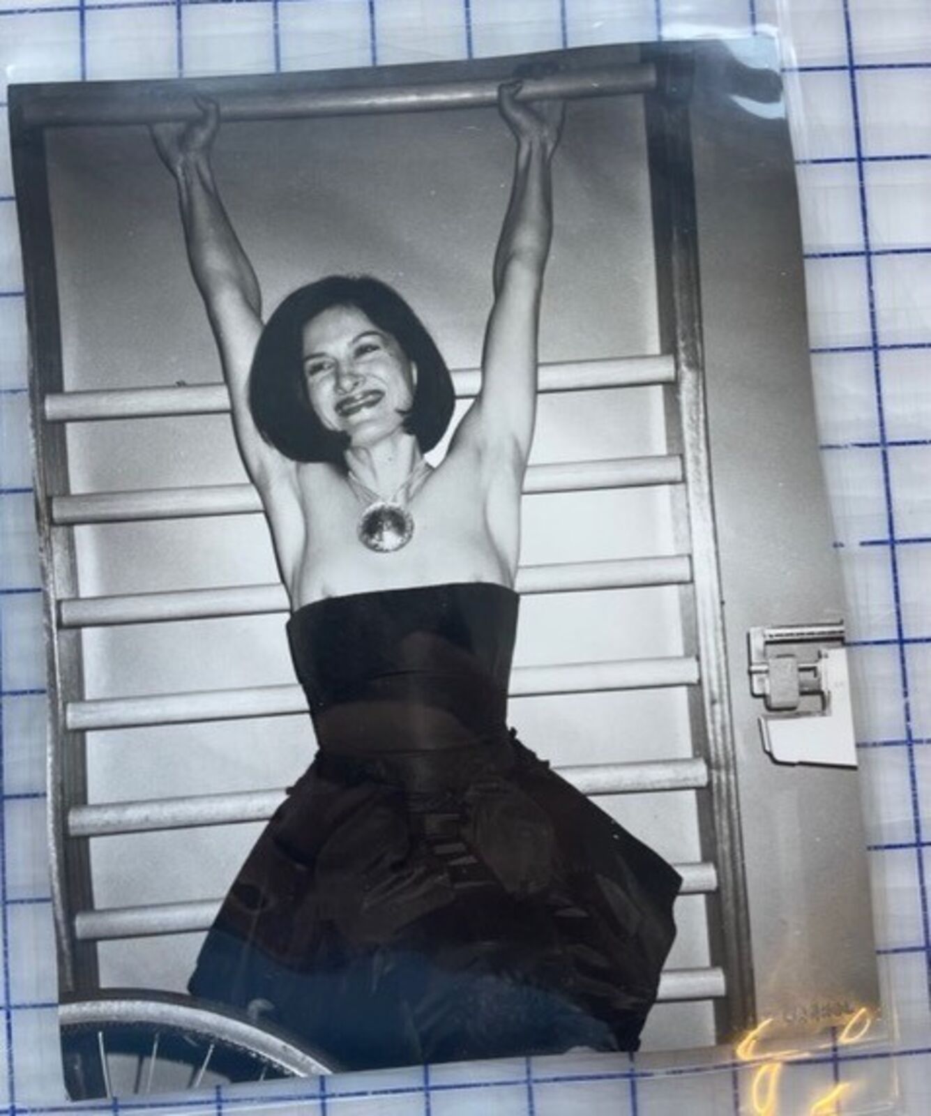 A black and white photo of a woman in a black dress.