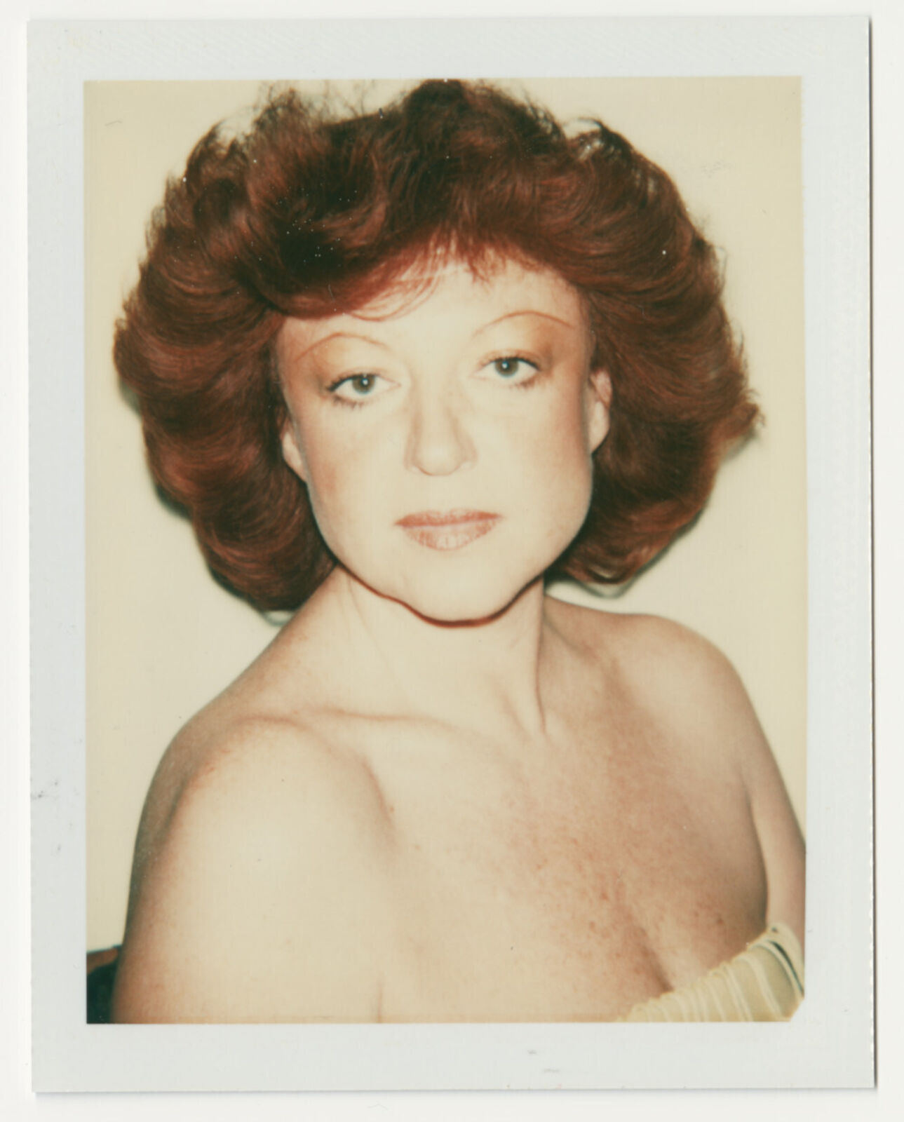 A polaroid photo of a woman with red hair. 