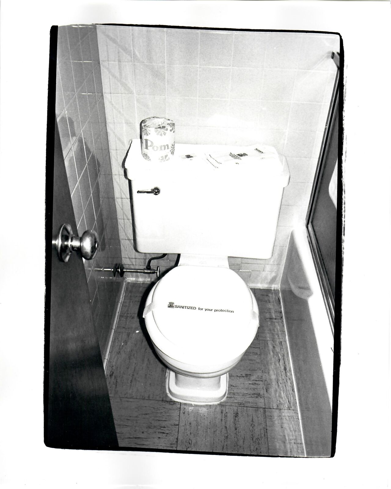 A black and white photo of a toilet in a bathroom.