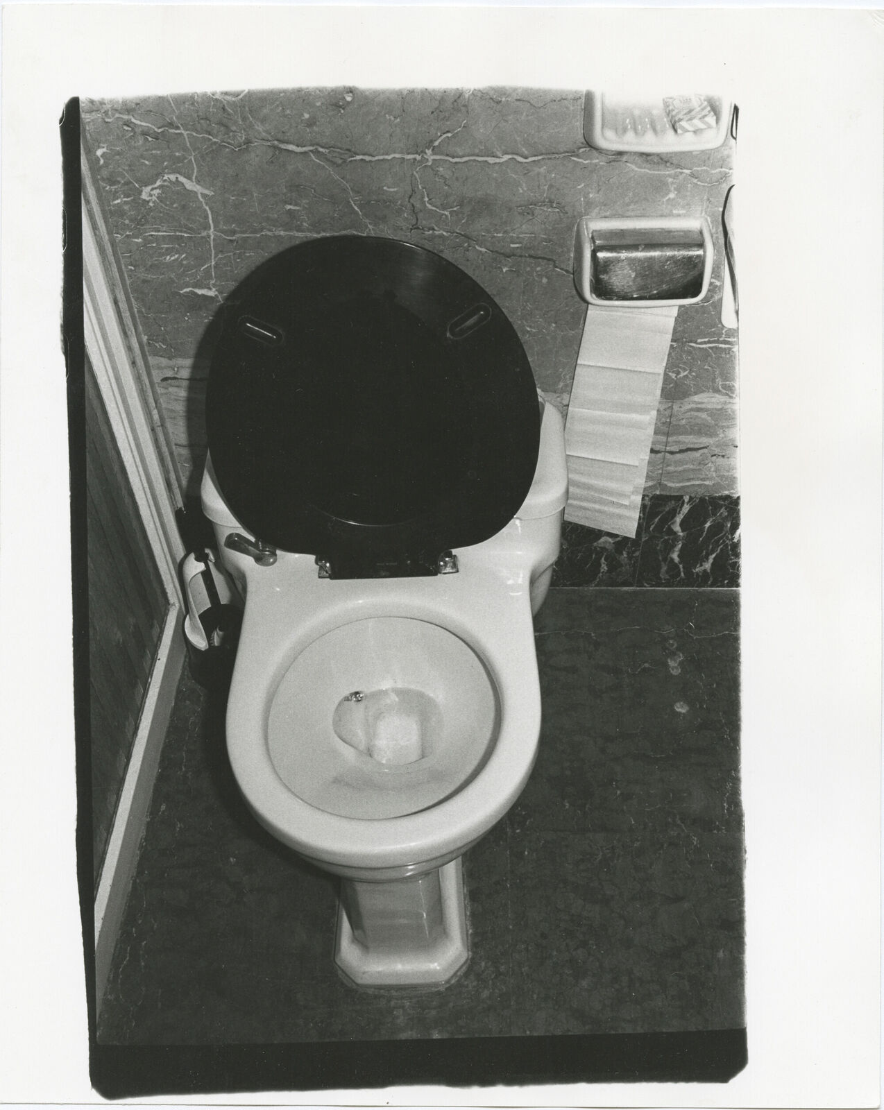 A black and white photo of a toilet in a bathroom.