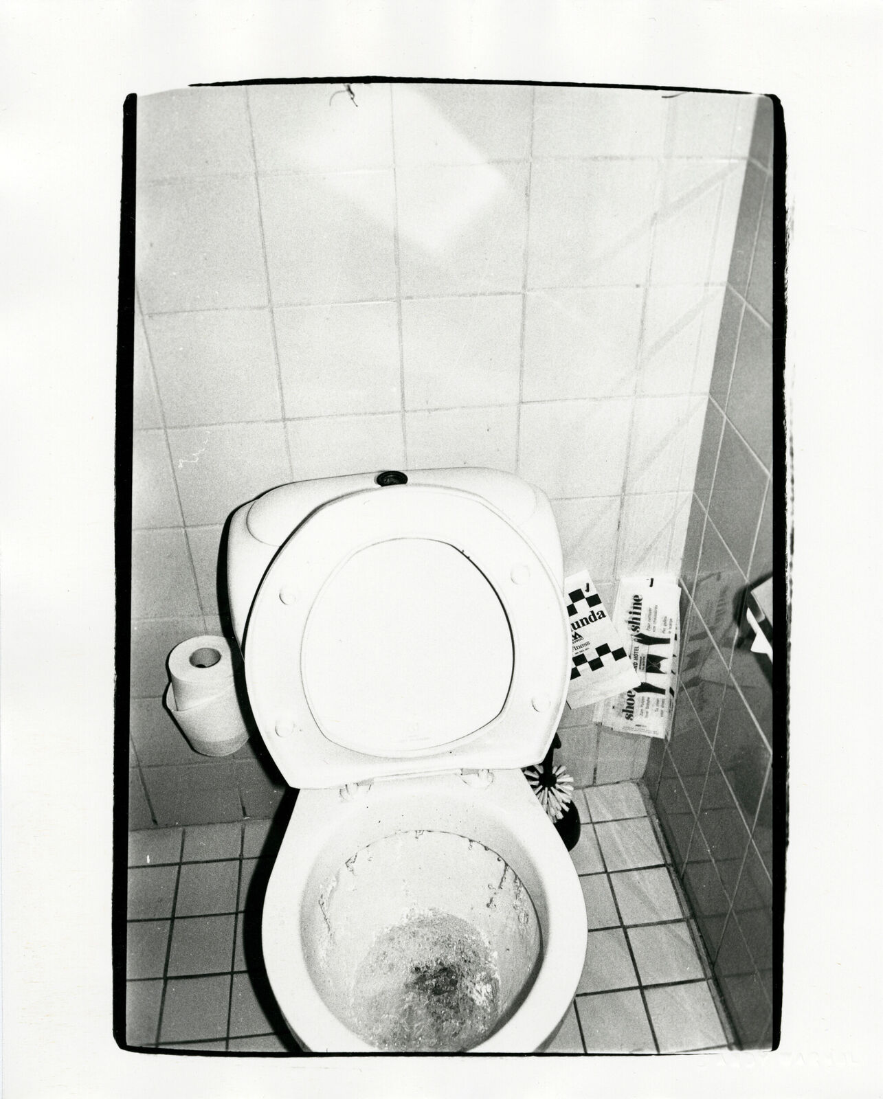 A black and white photo of a dirty toilet in a bathroom.