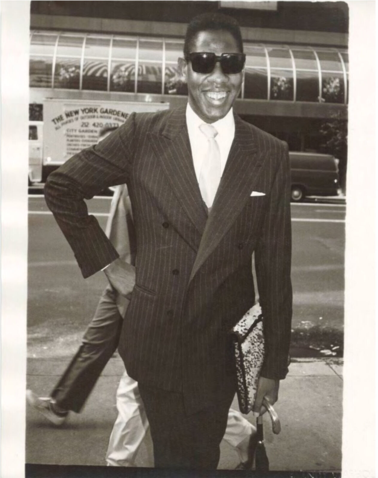 A black and white photo of a man in a suit and sunglasses.