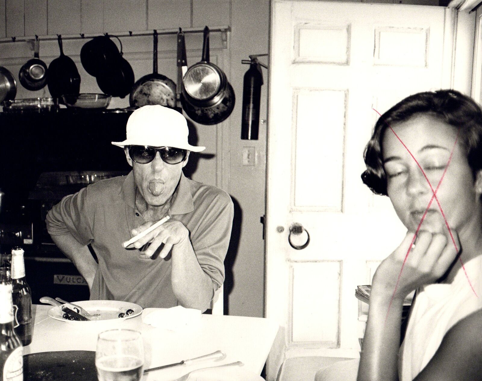 A man and a woman sitting at a table in a kitchen.