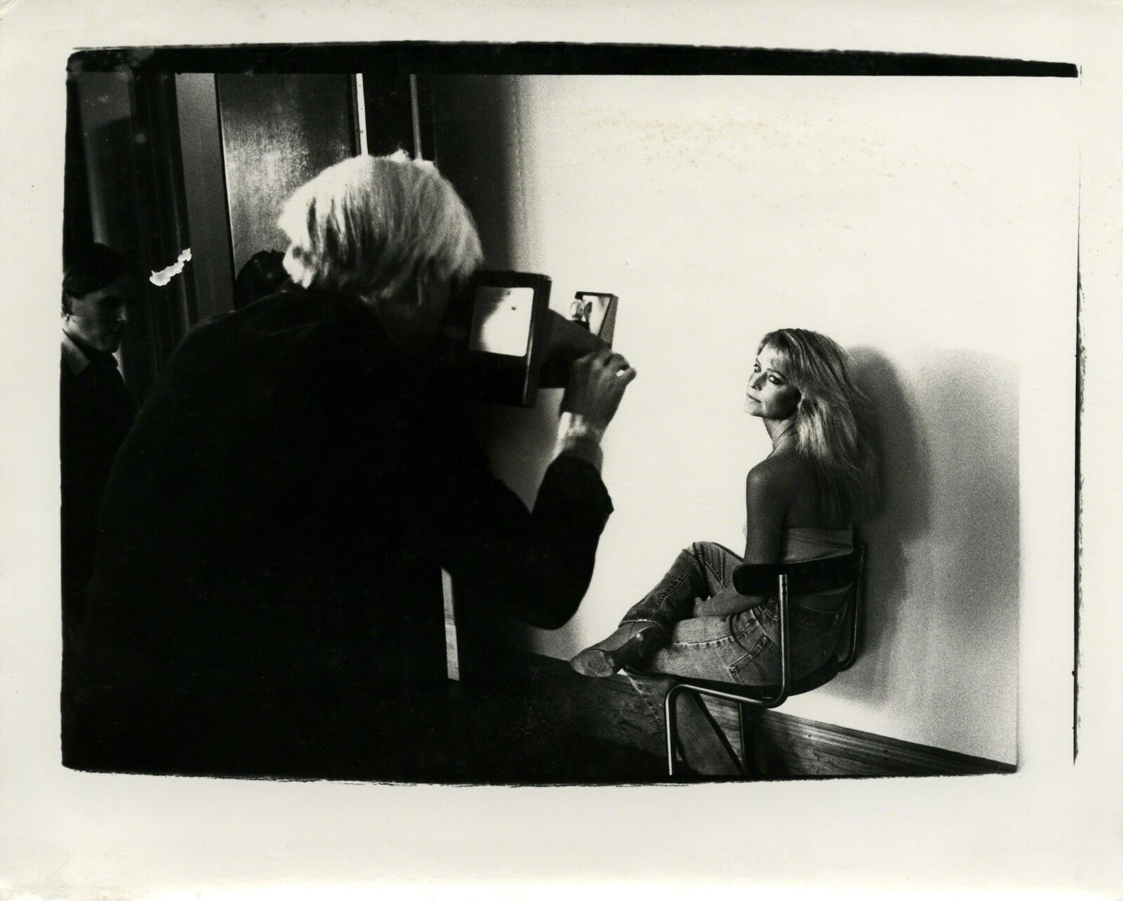 A black and white photo of a woman sitting in front of a mirror.