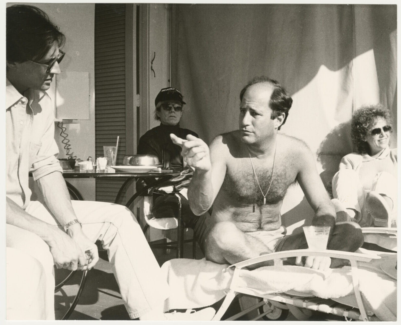 A group of people sitting around a table on a patio.