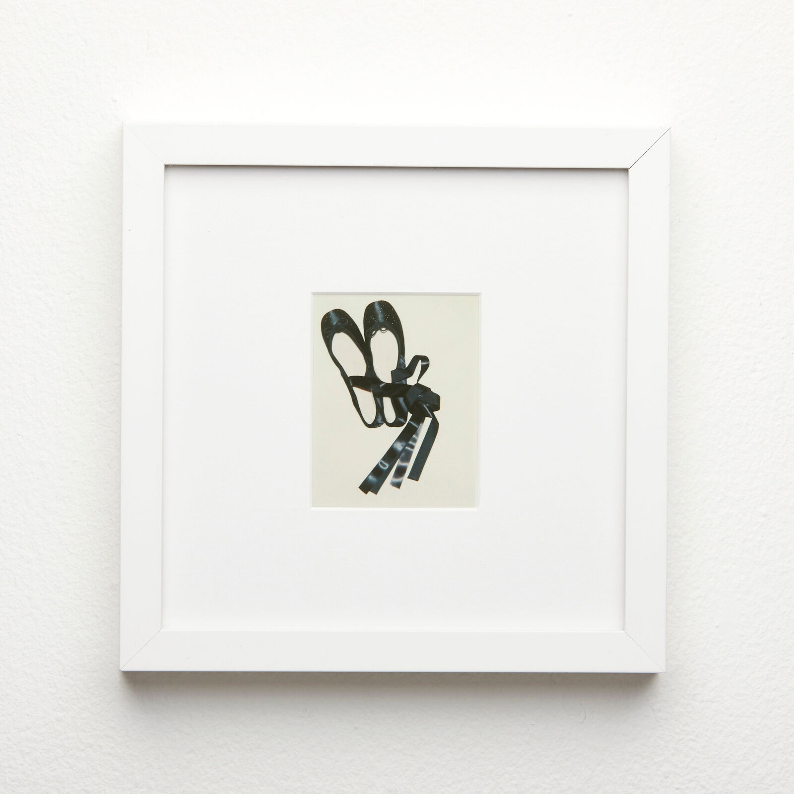 A black and white picture of a pair of shoes hanging on a wall.