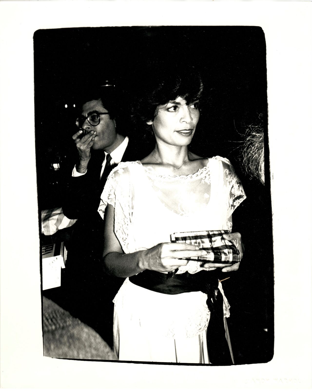 A black and white photo of a woman in a white dress.