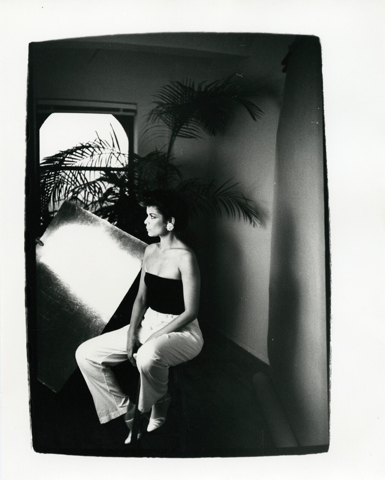 A black and white photo of a woman sitting on a chair.