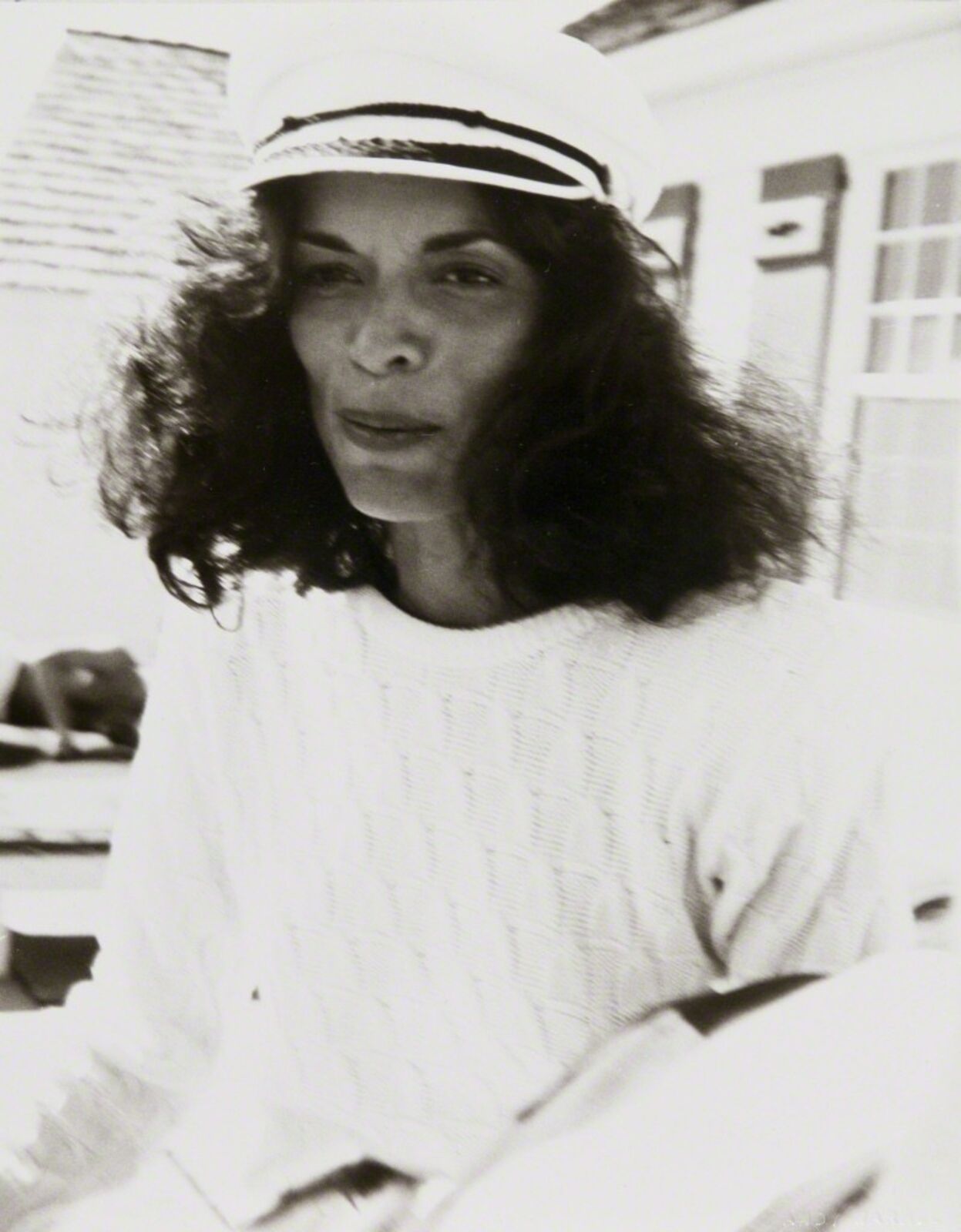 A black and white photo of a woman in a sailor's hat.