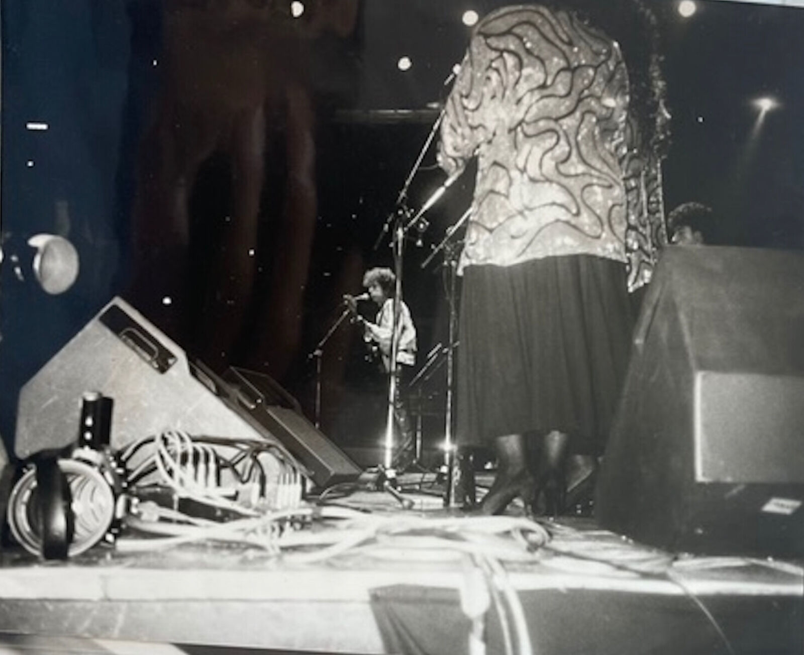 A black and white photo of a woman standing on a stage.