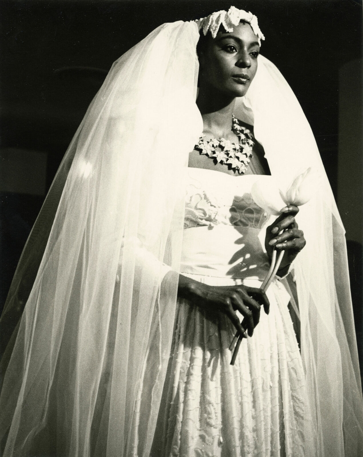 A black and white photo of a woman in a wedding dress.